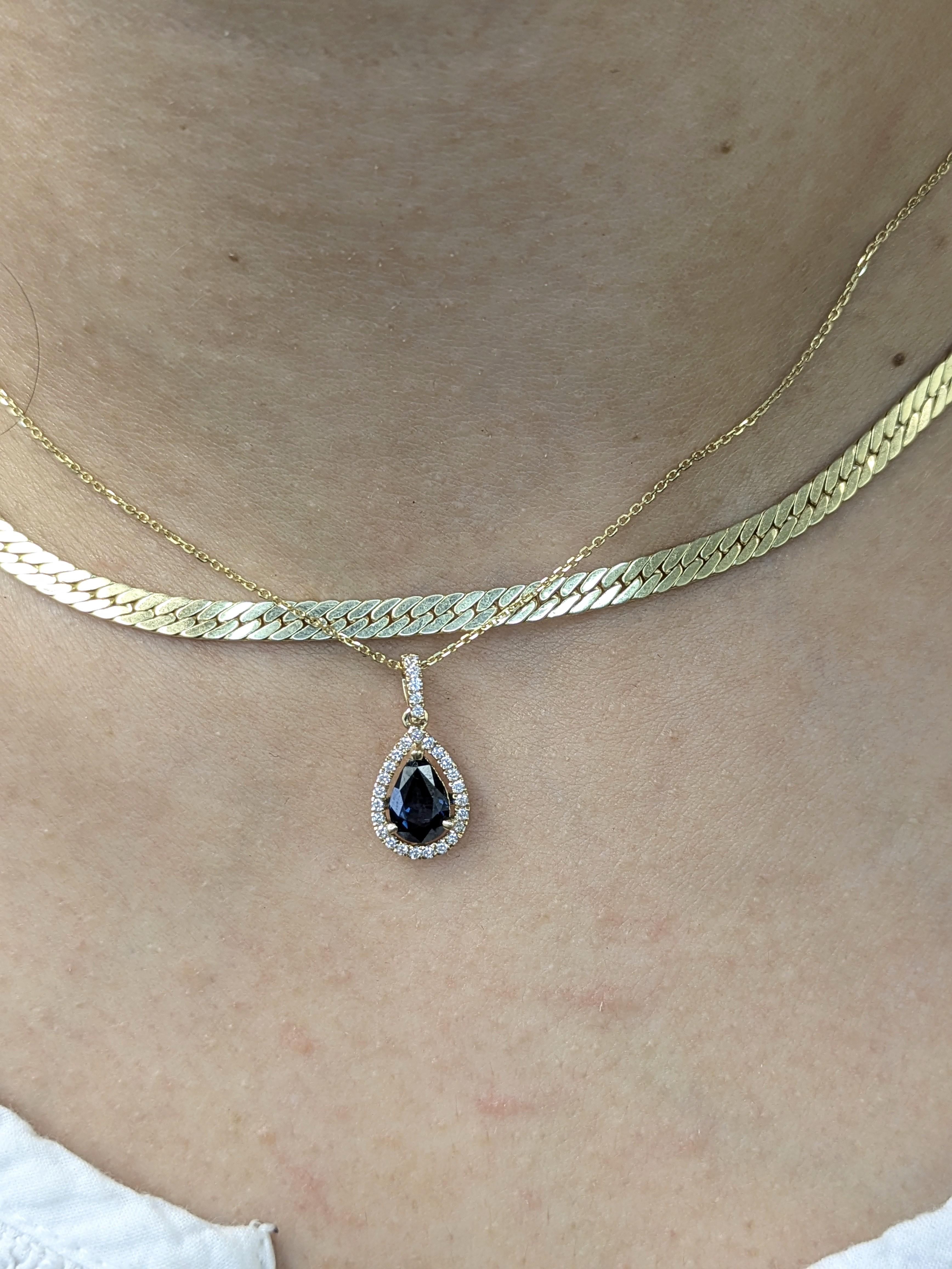 Elegante e classico, questo ciondolo a scorrimento mette in mostra uno zaffiro Ceylon a pera da 1,22 carati, avvolto da un'aureola di diamanti estratti dalla terra e da un castone con pavé, il tutto in solido oro giallo 14 carati. Un cimelio moderno