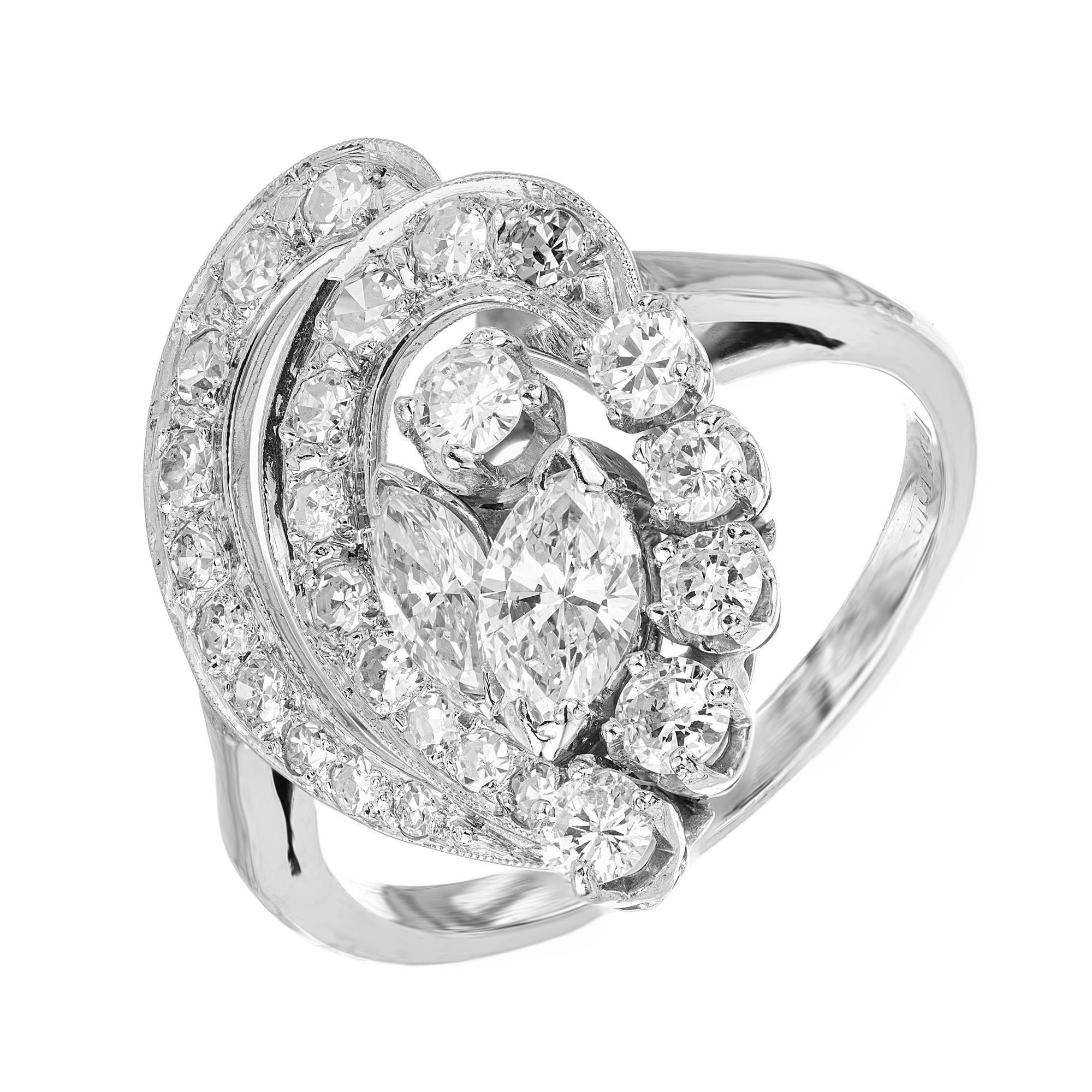 Découvrez cette bague de cocktail en diamant intemporelle des années 1950. Un chef-d'œuvre qui incarne parfaitement l'esthétique moderne du milieu du siècle. Cette bague de cocktail exquise met en valeur deux diamants centraux de forme marquise avec