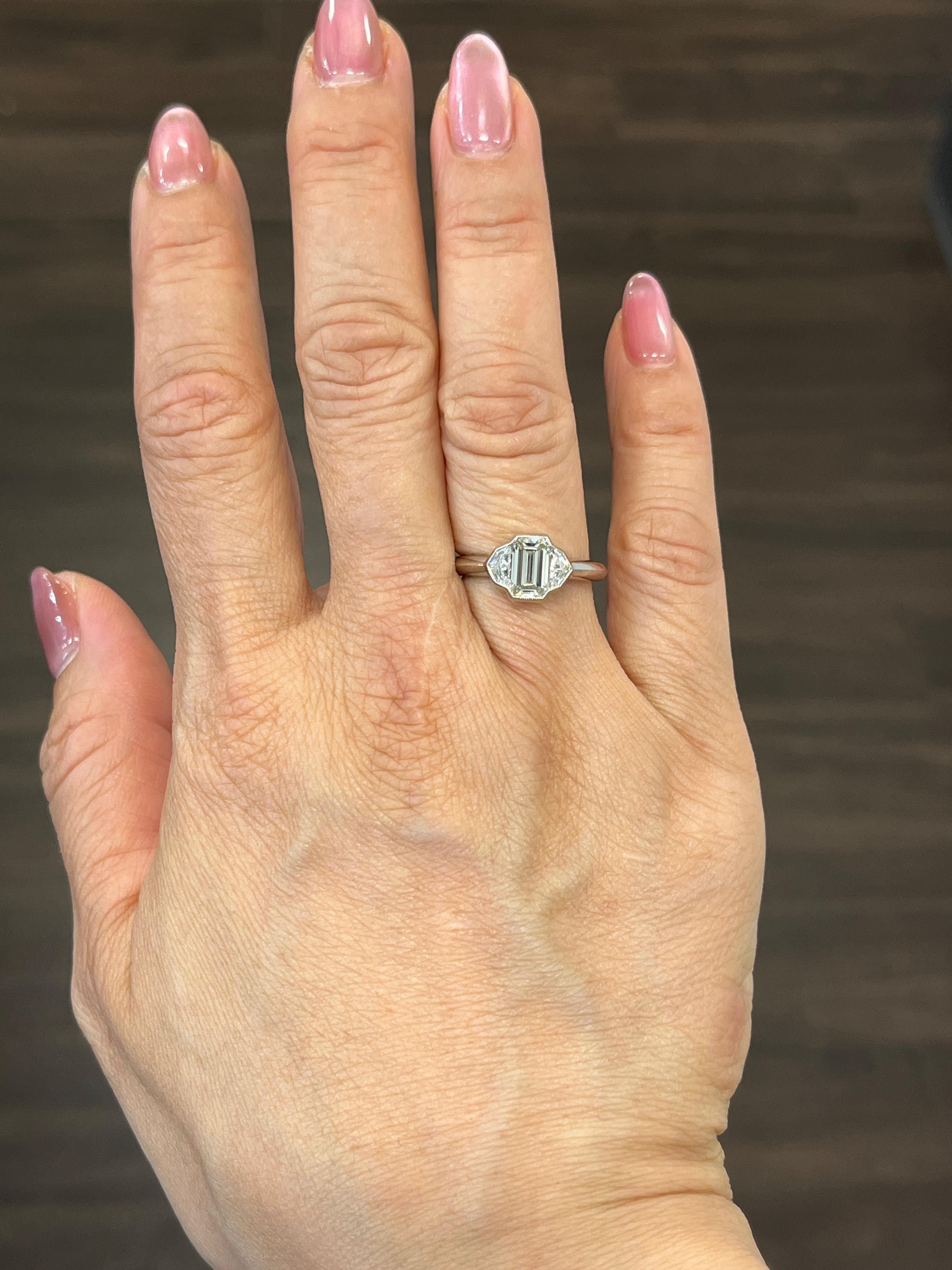 This stunning bezel set ring features a GIA certified emerald cut diamond weighing 1.23 ct. Two cadillac cut diamonds accompany the beautiful emerald. The diamond boasts a color of G/H with a clarity of VS1. Such a gorgeous ring to adorn any finger!