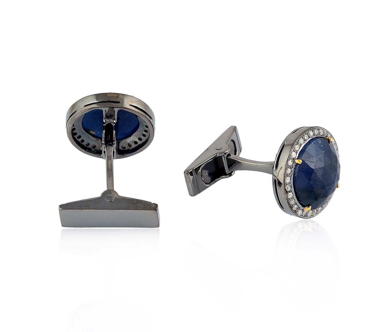 Fabriqués en or 18 carats et en argent sterling, ces boutons de manchette sont sertis à la main d'un saphir bleu de 12,34 carats et de diamants pavés de 0,39 carat en finition noircie.

Suivez la vitrine de MEGHNA JEWELS pour découvrir la dernière