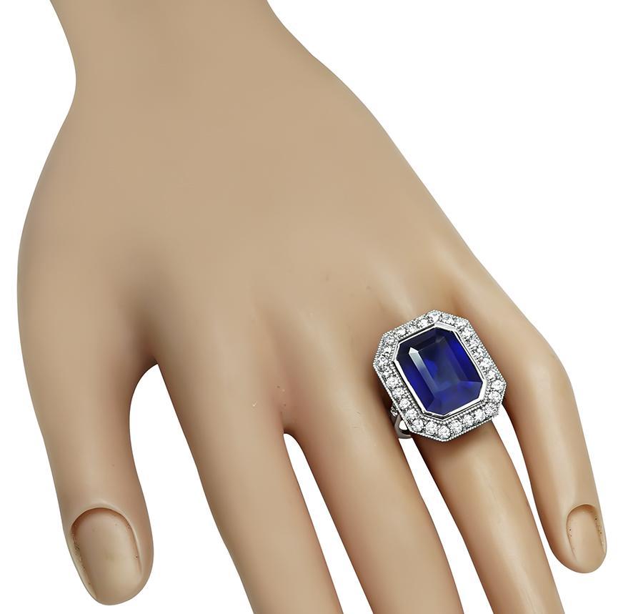 This is a stunning platinum engagement ring. The ring is centered with a lovely emerald cut sapphire that weighs approximately 12.35ct. The sapphire is accentuated by sparkling round cut diamonds that weigh approximately 1.25ct. The color of these