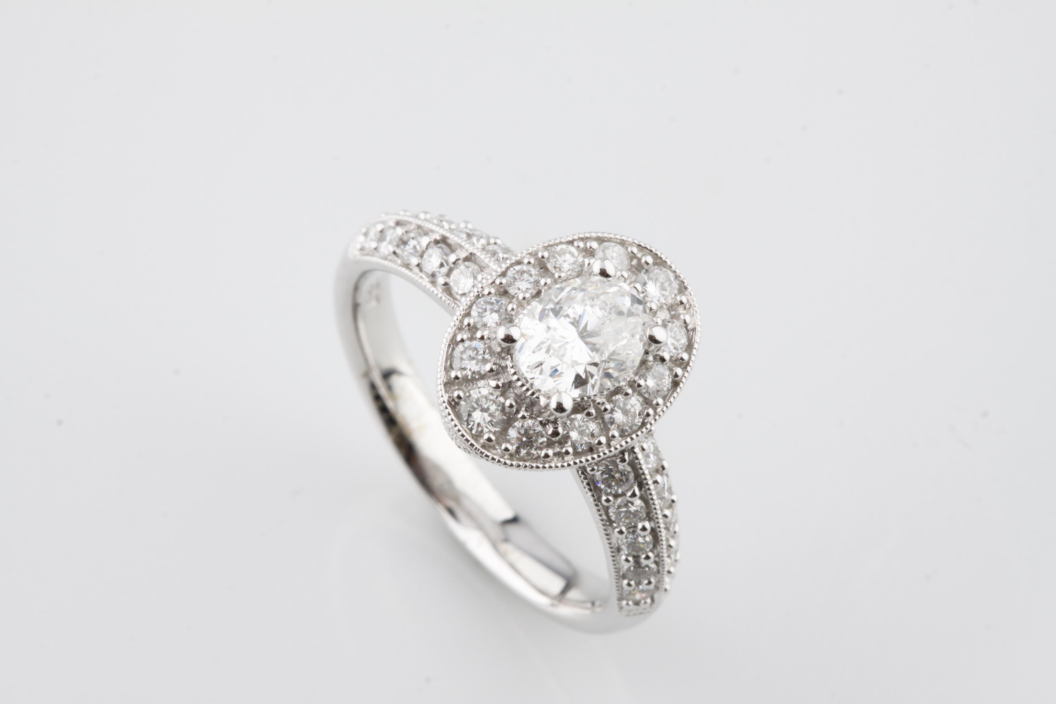 One electronically tested 18KT white gold ladies cast & assembled diamond ring with a bright & patterned finish.
Condition is new, good workmanship.
The ring features a diamond solitaire set within a gallery of diamonds, supported by diamonds set