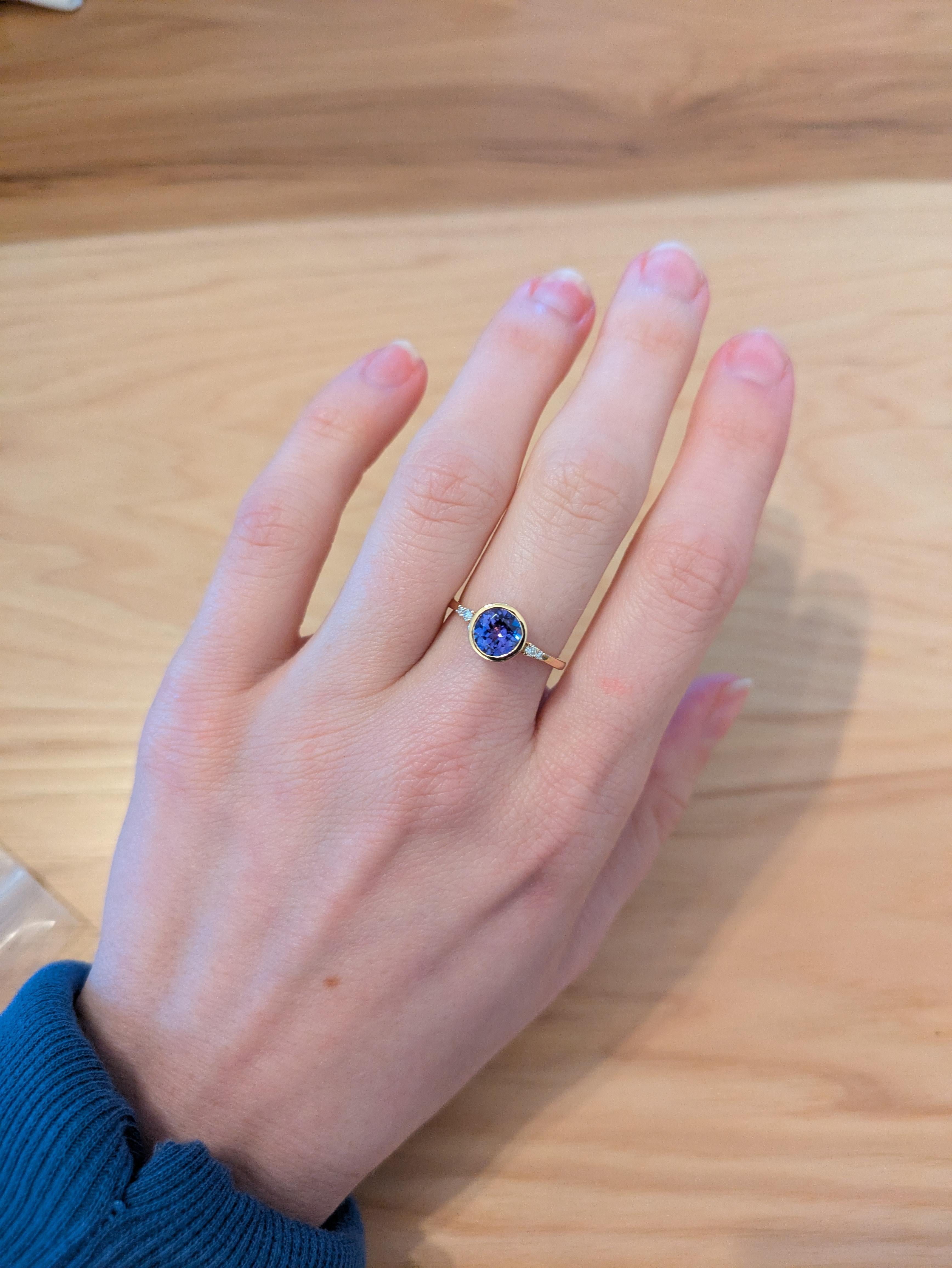 This delicate 1.24-carat tanzanite ring features a stunning blue-violet gemstone, accented by earth-mined diamonds in a chic bezel setting. Crafted in solid 14k gold, it embodies both elegance and modern charm. With its December birthstone, it's an