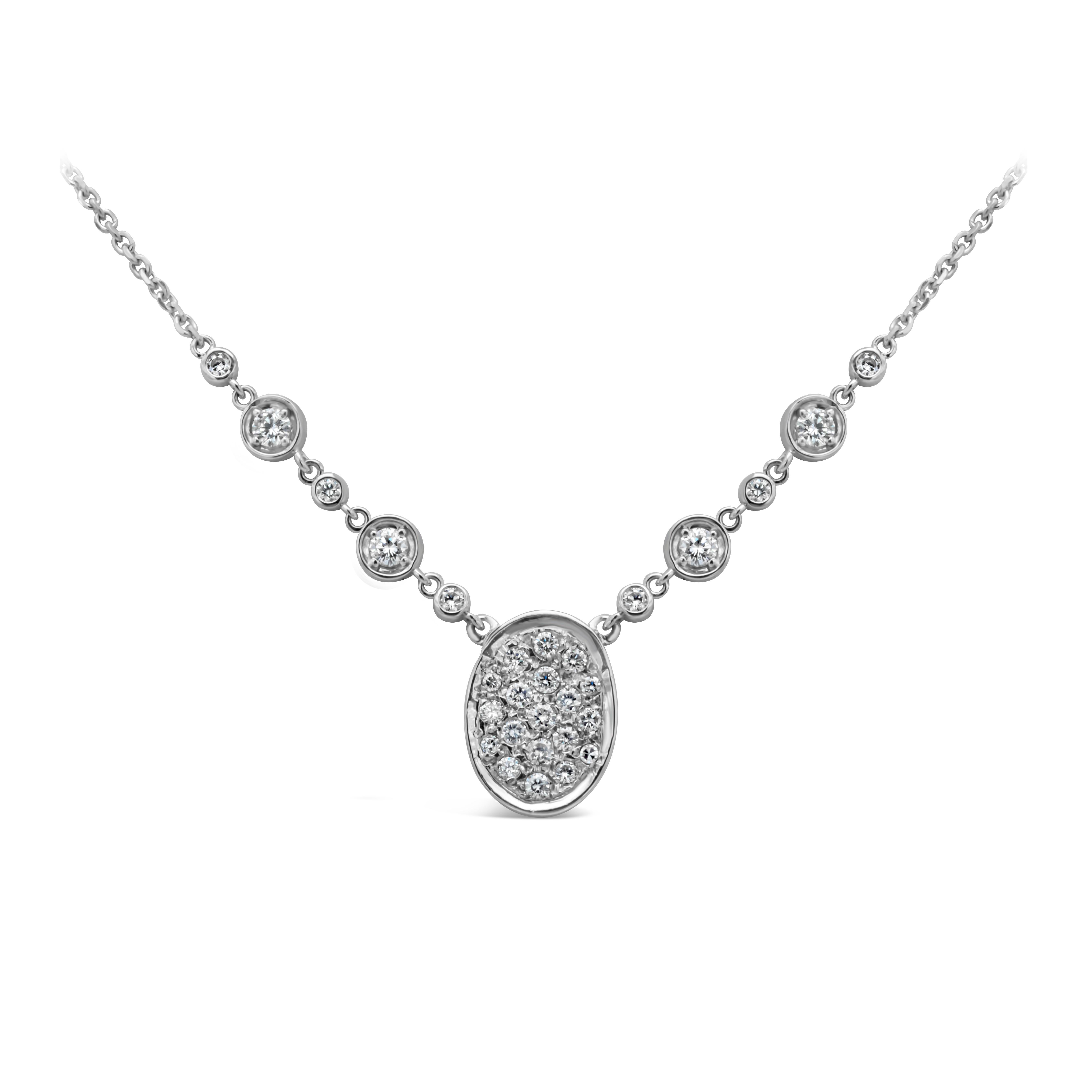 A gorgeous pendant necklace, showcasing a cluster of round brilliant cut diamonds weighing 1.24 carats total with F color and VS-SI clarity, set in a micropavé setting. Accented by bezel-set diamonds by the yard chain. Finely made with 14K white