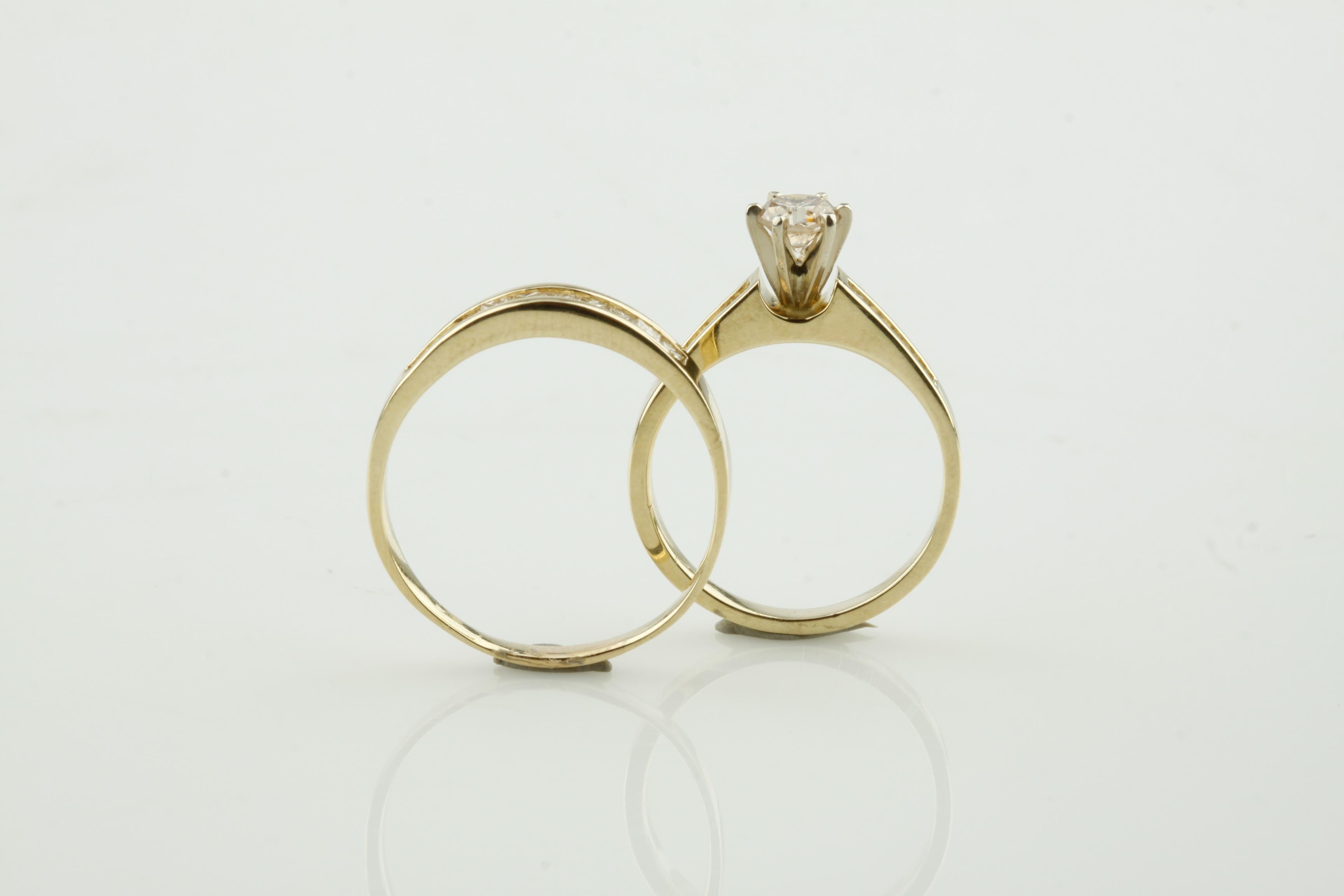 Beautiful Wedding Set in 14k Yellow Gold
Includes Engagement Ring and Wedding Band
Engagement Ring Features 0.44 Carat Round Solitaire Diamond
Color: L
Clarity: VS-2
Both Rings Include a row of Channel/Invisible Set Princess Cut Diamond