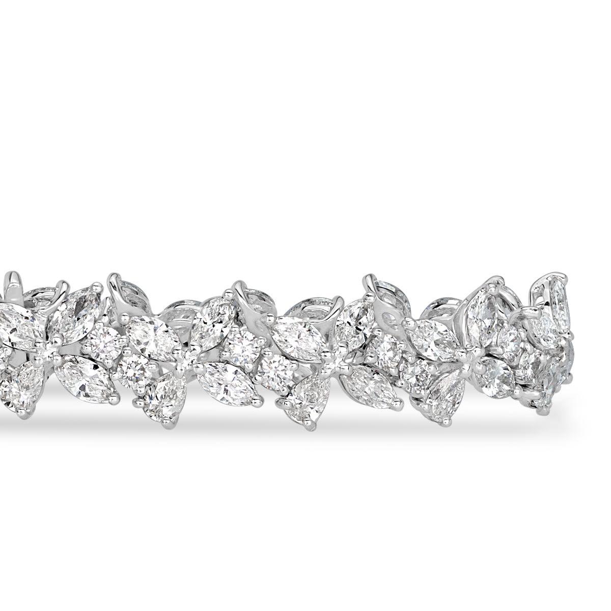 This captivating cluster diamond bracelet features a mesmerizing trio of pear shaped, marquise and round brilliant cut diamonds hand set in an exquisite floral pattern. The diamonds total 12.41ct in weight and are graded at E-F in color, VS1-VS2 in