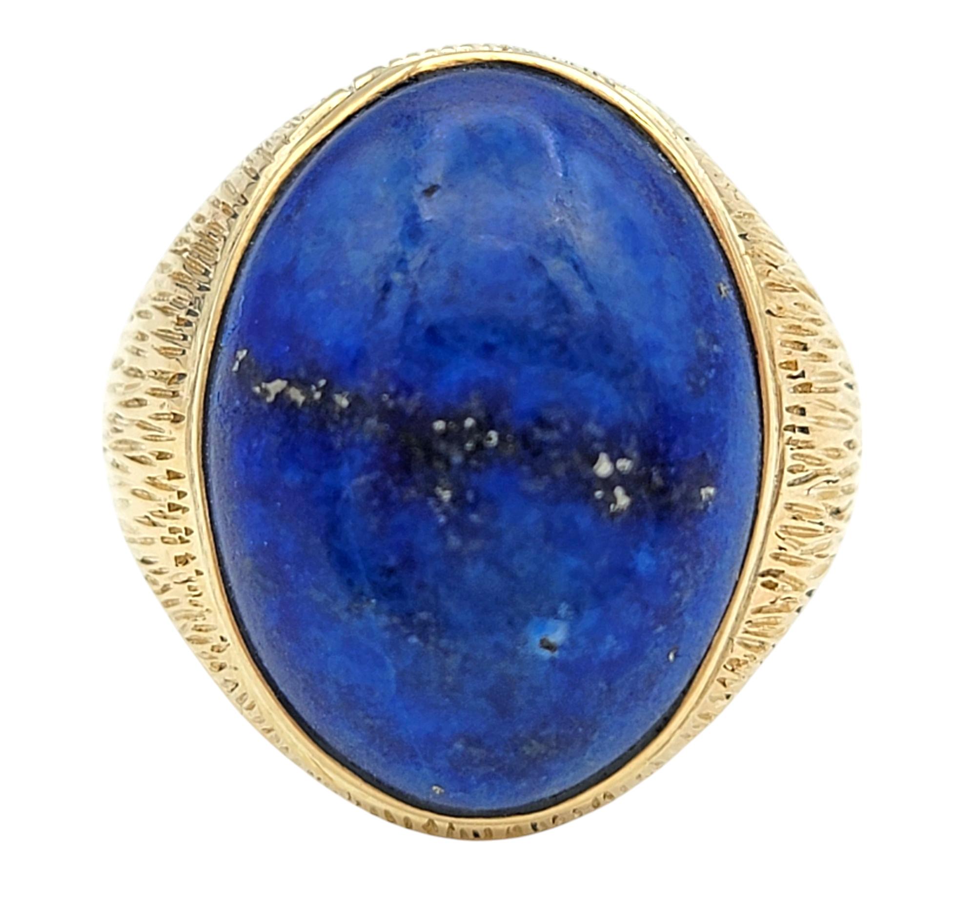 Ring Size: 8.5

Bold and sophisticated, this striking ring showcases a rich blue 12.45 carat cabochon cut lapis lazuli, its smooth oval shape exuding a timeless appeal. The deep azure hue of the lapis, accented with its natural golden flecks,