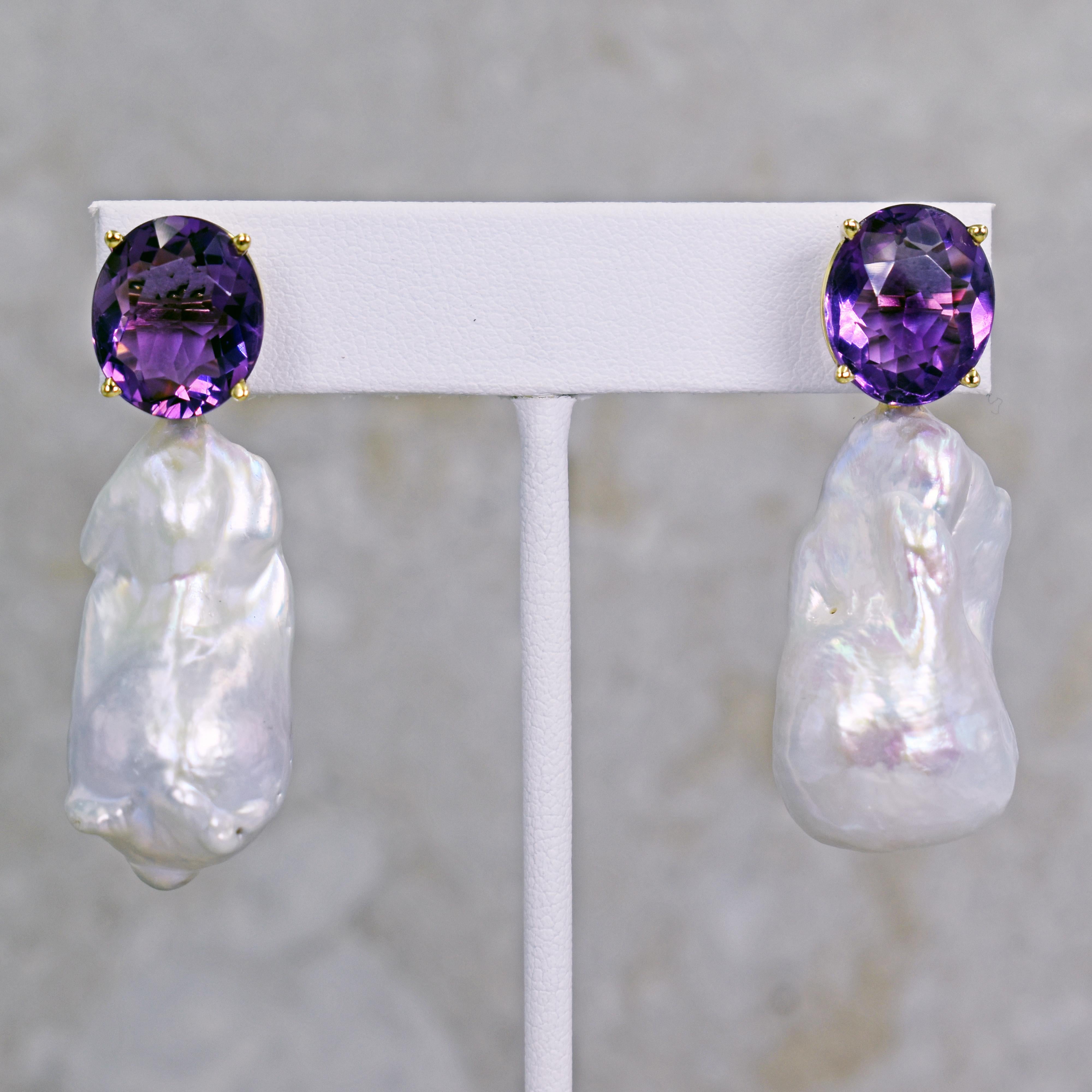 Gorgeous and unique 14k yellow gold stud earrings featuring two oval-cut Amethyst gemstones, totaling 12.46 carats, with large Freshwater Baroque Pearls. Stud earrings are 1.94 inches or 49 mm in length. These artisan statement drop earrings have