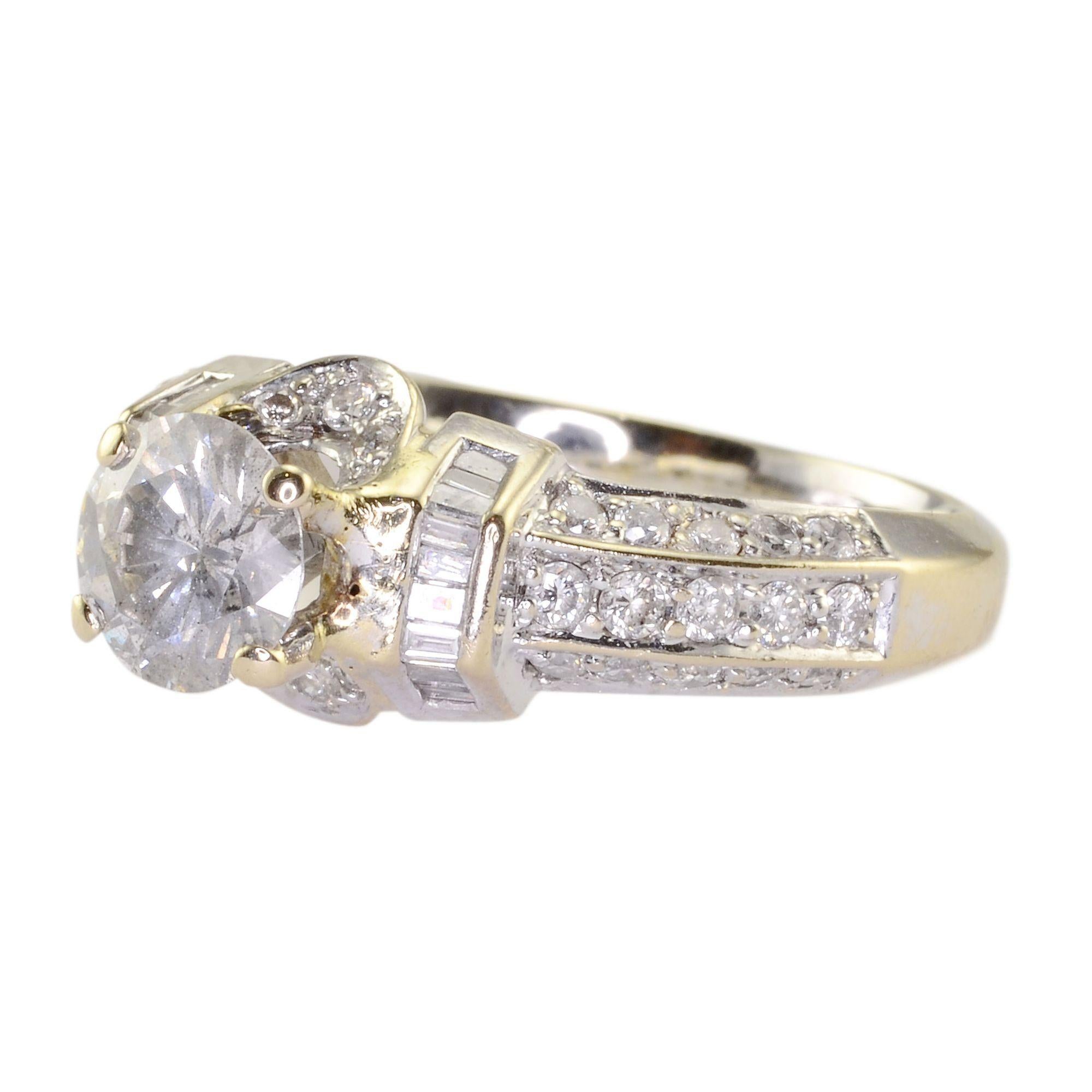 Estate 1.25 carat diamond 18K white gold engagement ring. This ring has one center round diamond at 1.25 carats I2 clarity J-K color with 10 baguette diamonds at 0.20 carat total weight and 36 pave diamonds at 0.33 carat total weight. Appraised at