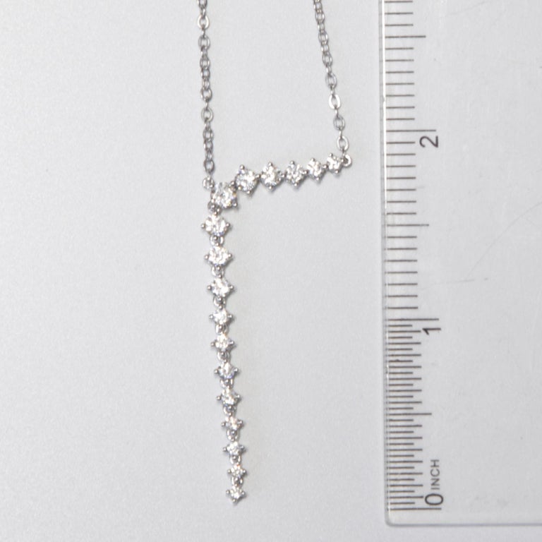 This necklace set in 14k White Gold has a series of graduated round white diamonds. The setting is anchored at the first six stones, but the remaining 11 stones freely dangle starting approximately 1/3 of the way through the design, for a playful