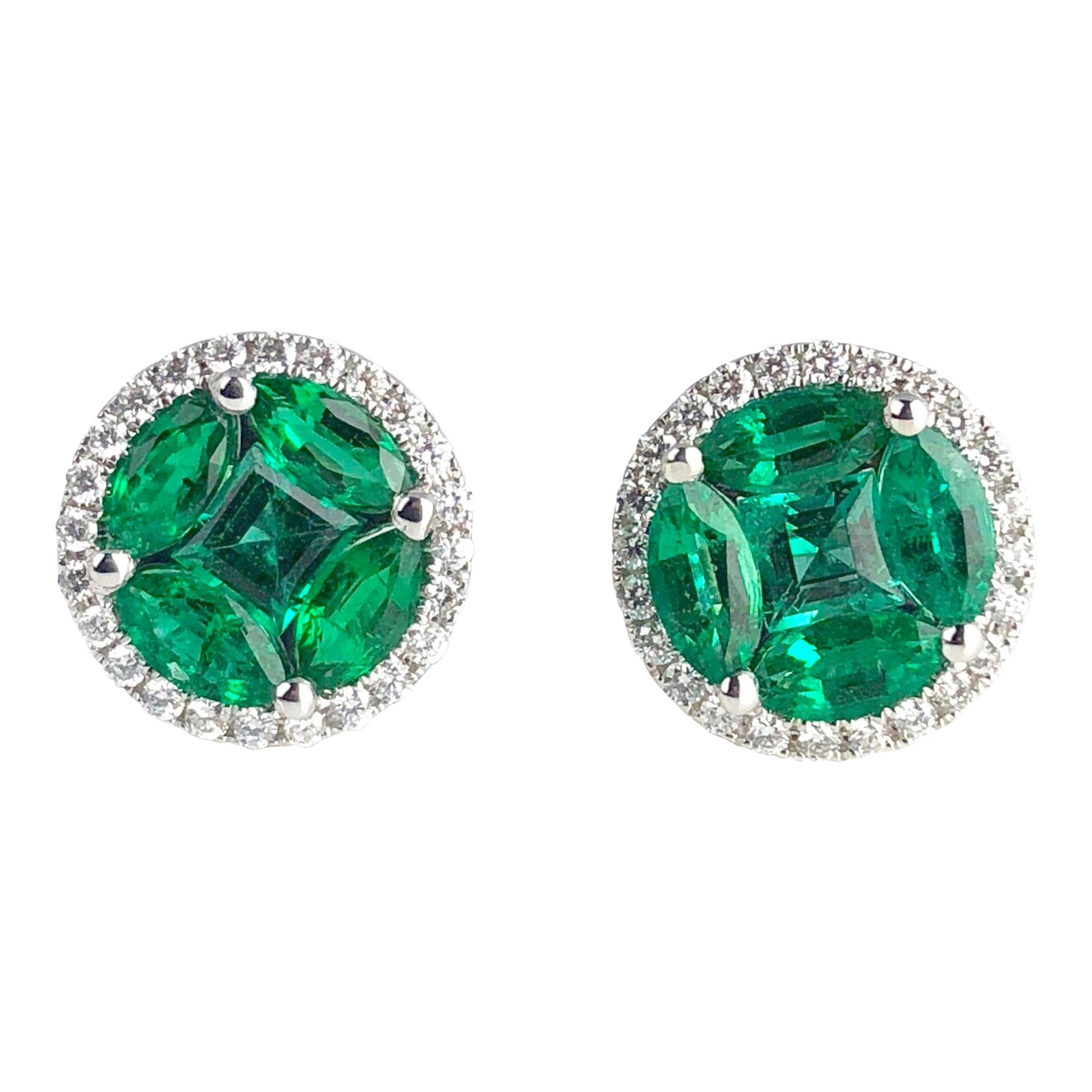 Questi orecchini a perno rotondi presentano un centro a grappolo di smeraldi verdi brillanti (peso approssimativo 1,25 carati), circondato da un'aureola di diamanti bianchi rotondi (peso approssimativo 0,20 carati). Il mosaico è stato realizzato con