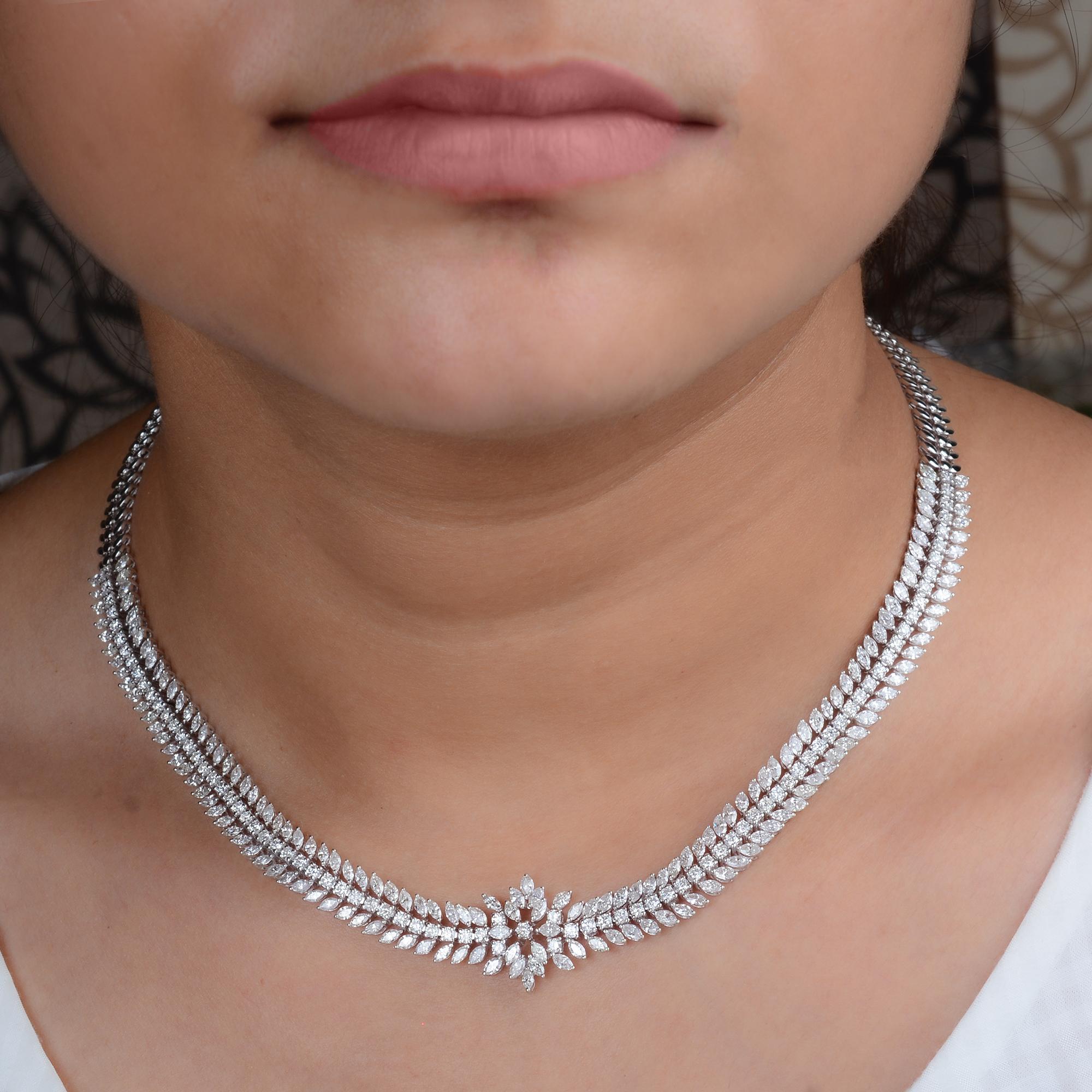 Este collar gargantilla de diamantes de 12,5 quilates, claridad SI y color HI, de oro blanco de 18 quilates, tiene diamantes talla marquesa y brillante redondo. En el centro, los diamantes se agrupan en una flor como punto focal floral.
Los