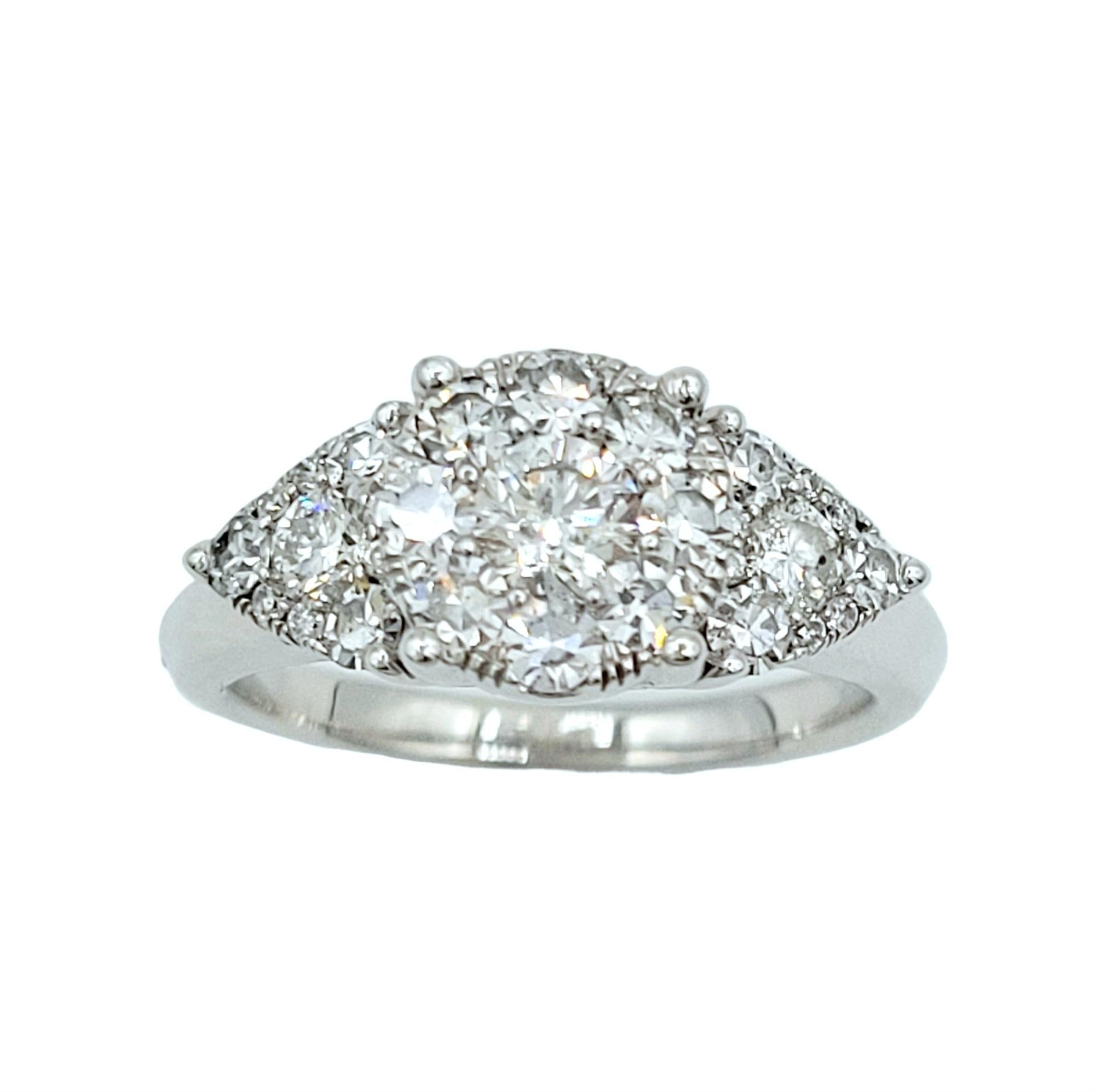 Ring Size: 6.75

This shimmering diamond ring, set in 14 karat white gold, features a captivating and clever design that creates the illusion of larger stones and magnificent sparkle. The centerpiece of the ring comprises a round diamond cluster