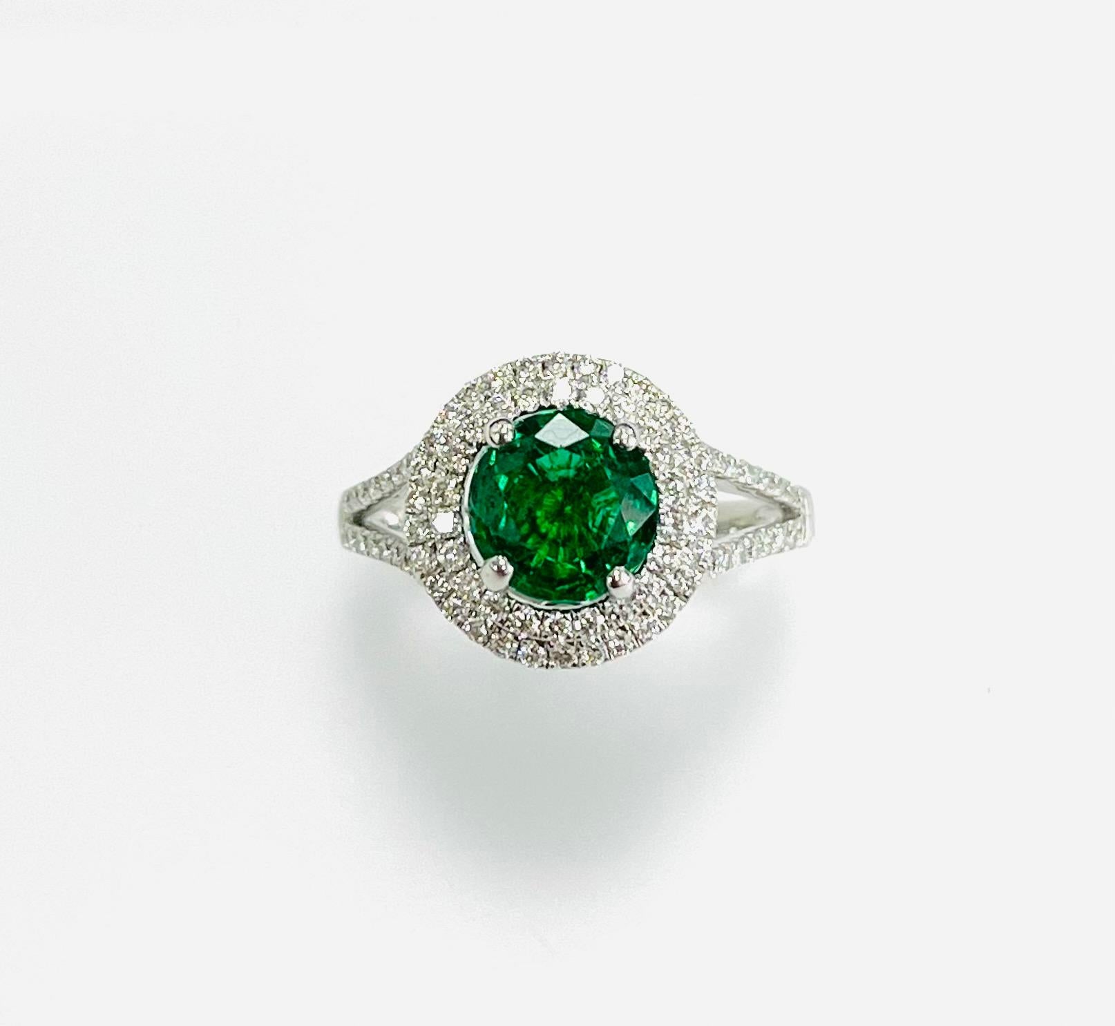 1.25 Carat Zambian round emerald set in 18k white gold ring with 0.59 carat diamonds in double halo  and half way  the split shank.