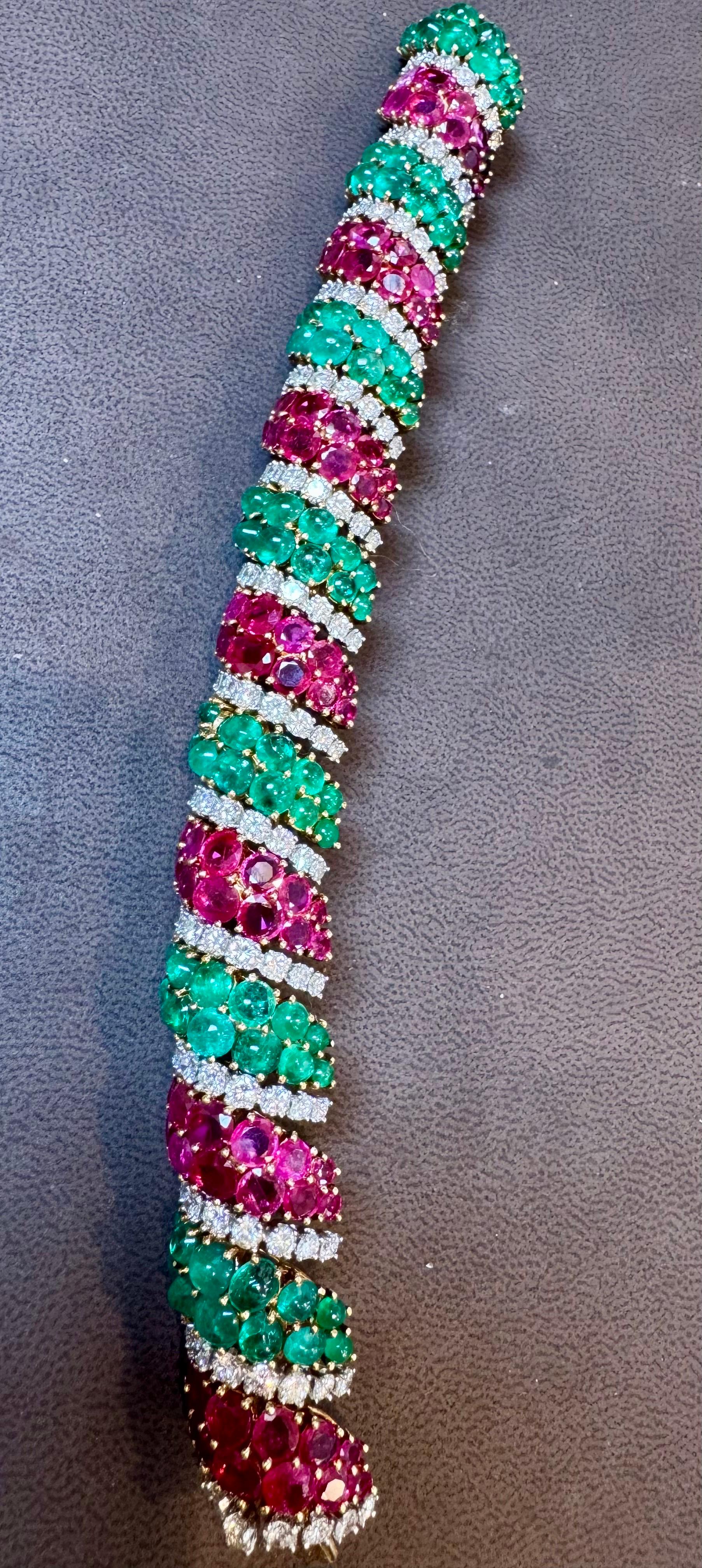 Vintage de haute qualité des années 1960  Bracelet serti d'émeraudes, de rubis et de diamants ronds de taille brillant montés en or jaune 18K à motif tressé. Poids : 99 grammes. 
Mesures approximatives : Longueur 8