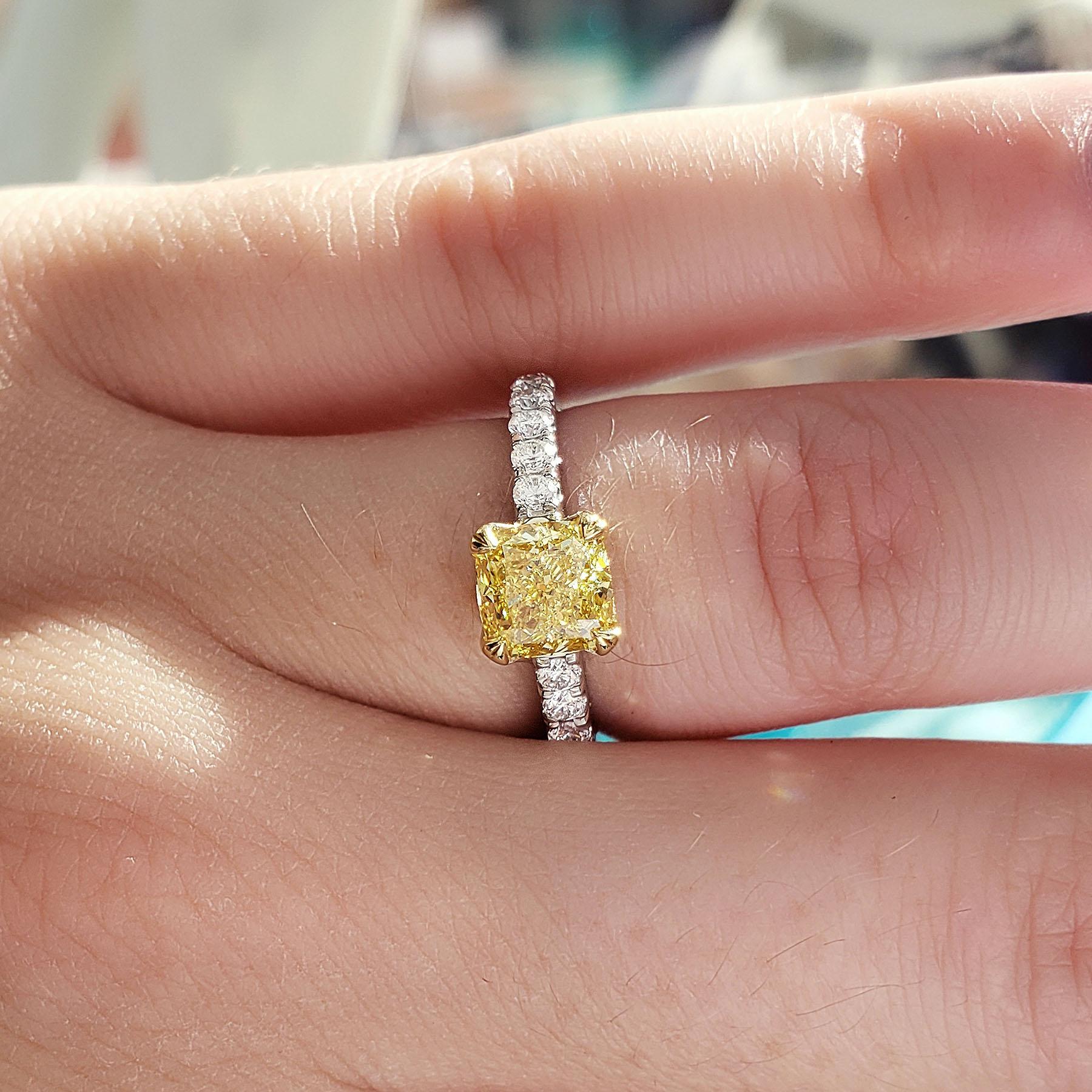  This beautiful canary diamond engagement ring flaunts a 1.00 Ct. Fancy Yellow Cushion cut diamond with SI1 clarity. Round cut diamonds (.25 ctw.) are placed down the shank in U-setting. 
Ring Details
Metal	: 18K Gold
Setting Type	: U-Pave
Total