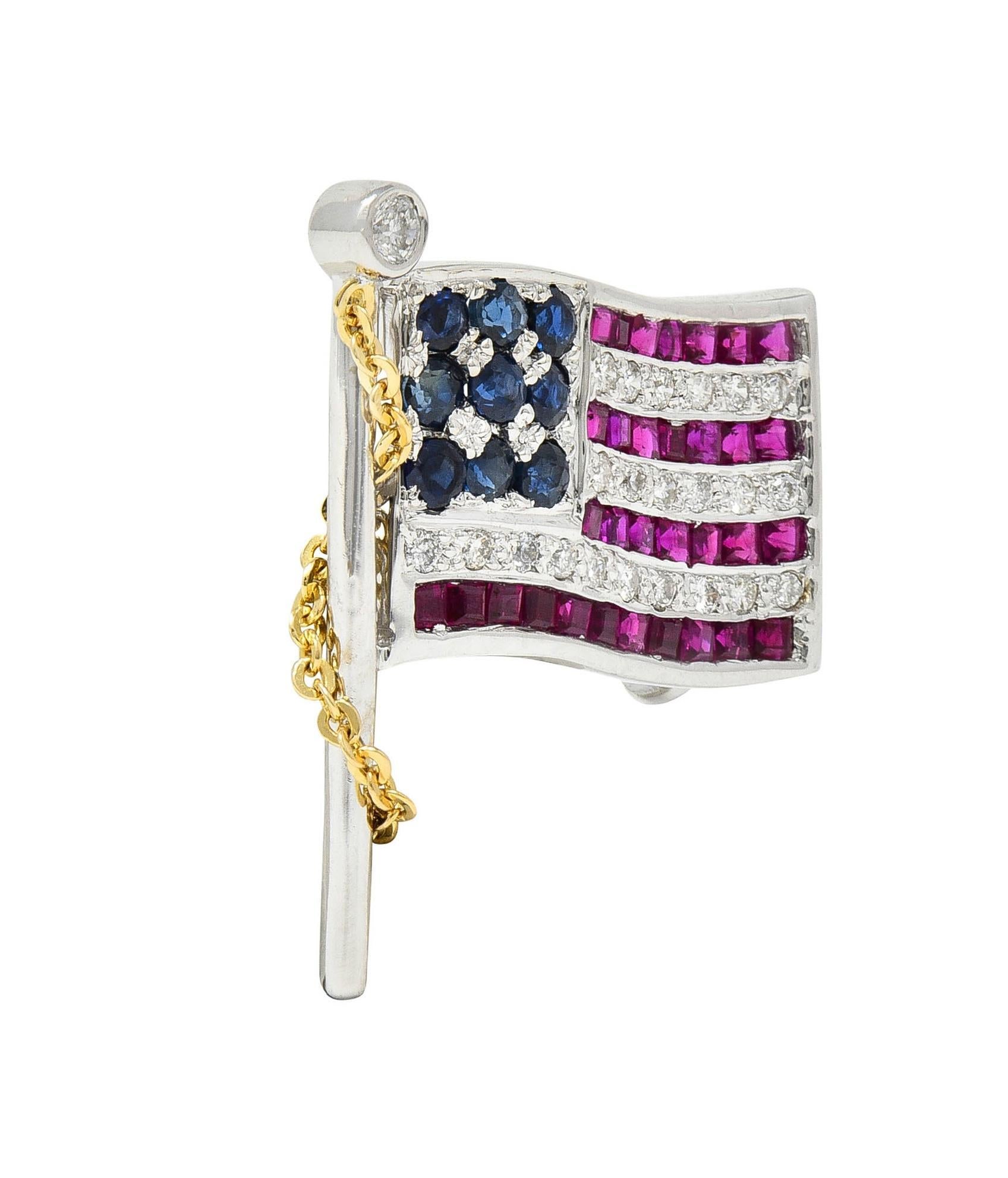 Designed as a white gold American flag comprised of sapphires, rubies, and diamonds 
Sapphires are round cut and transparent, medium to dark blue in color
Weighing approximately 0.36 carat total - bead set as stars
Rubies are square step-cut and