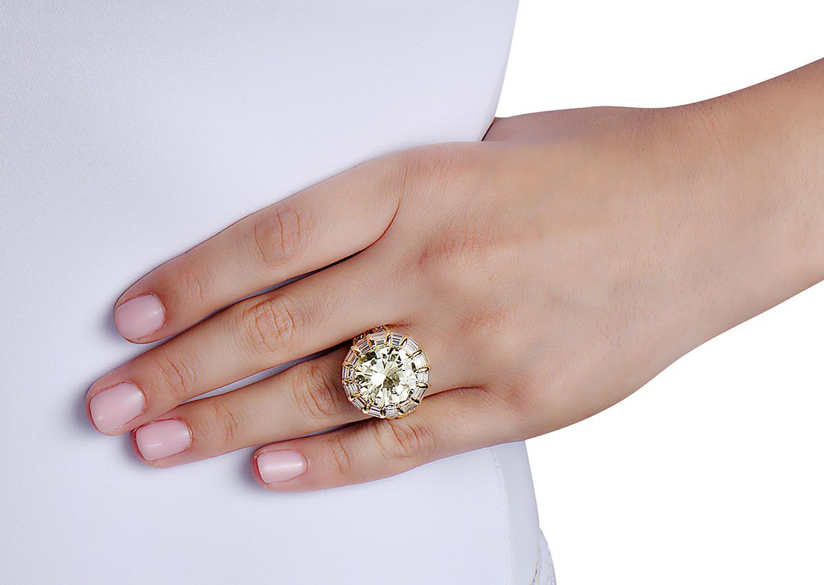 This estate cocktail ring signed by Nardi features a 12.50 carat round brilliant O-P color VVS clarity center stone set in 18K yellow gold with rectangular and square baguette cut diamonds. *The central stone looks whiter than in pictures*

Made in