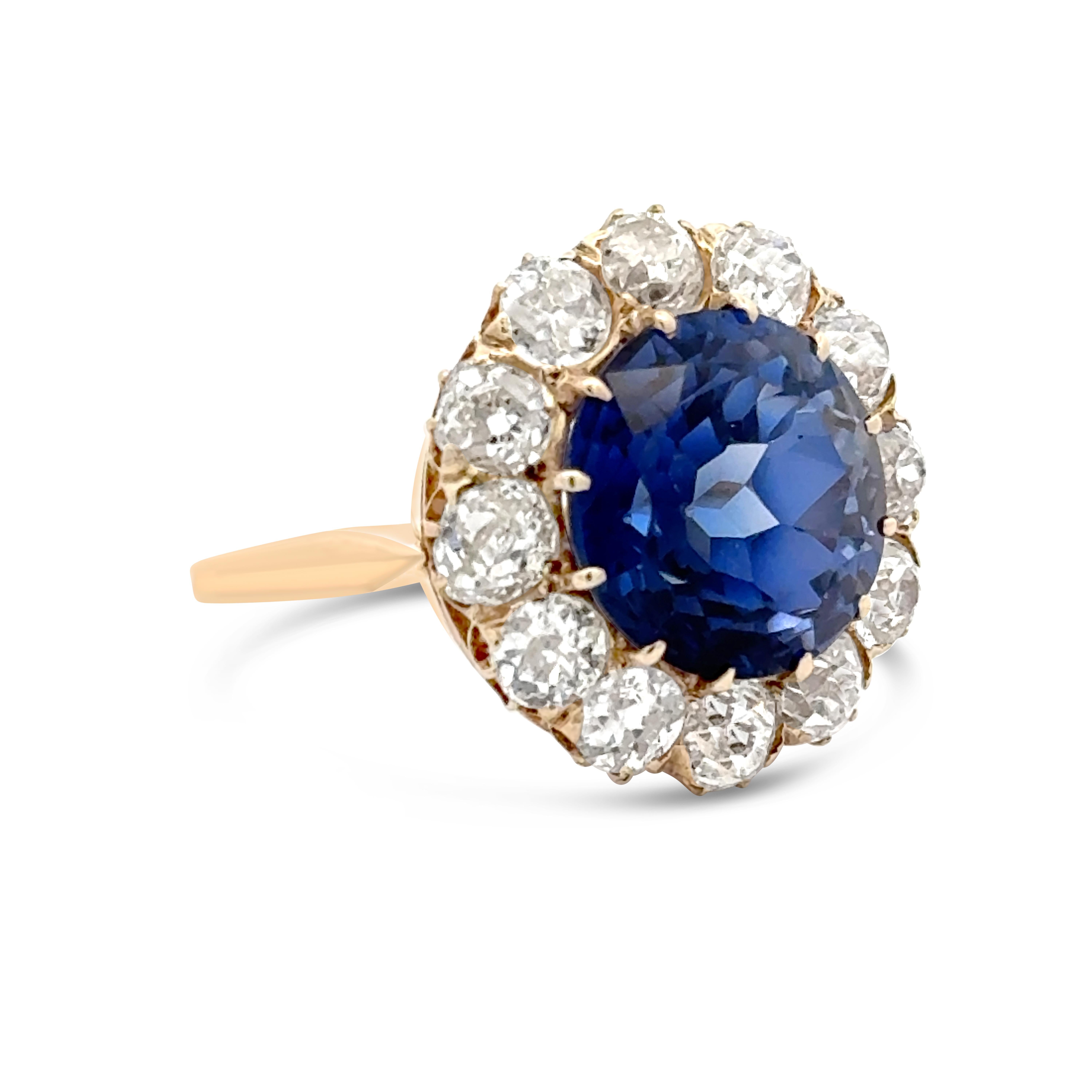 A fabulous antique cocktail ring, showcasing a 9.50 carats round cut synthetic sapphire, set on a twelve prong setting. Accented by round cut natural old cut diamonds weighing approximately 3.00 carats total, set on a beautiful halo design. Finely