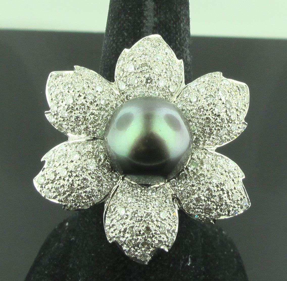 Set in 18 karat white gold is a 12.50 mm Black South Sea Pearl surrounded by 6 petals of 174 round brilliant cut diamonds with a total diamond weight of 3.50 carats.  G in color, VVS in clarity.  Ring size is 8. Can be sized 