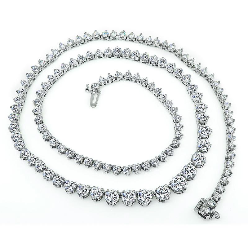 This is an elegant 18k white gold tennis necklace. The necklace is set with sparkling round cut diamonds that weigh approximately 12.55ct. The color of these diamonds is G-H with VS clarity. The necklace has a tapering width from 3mm to 5.5mm. The