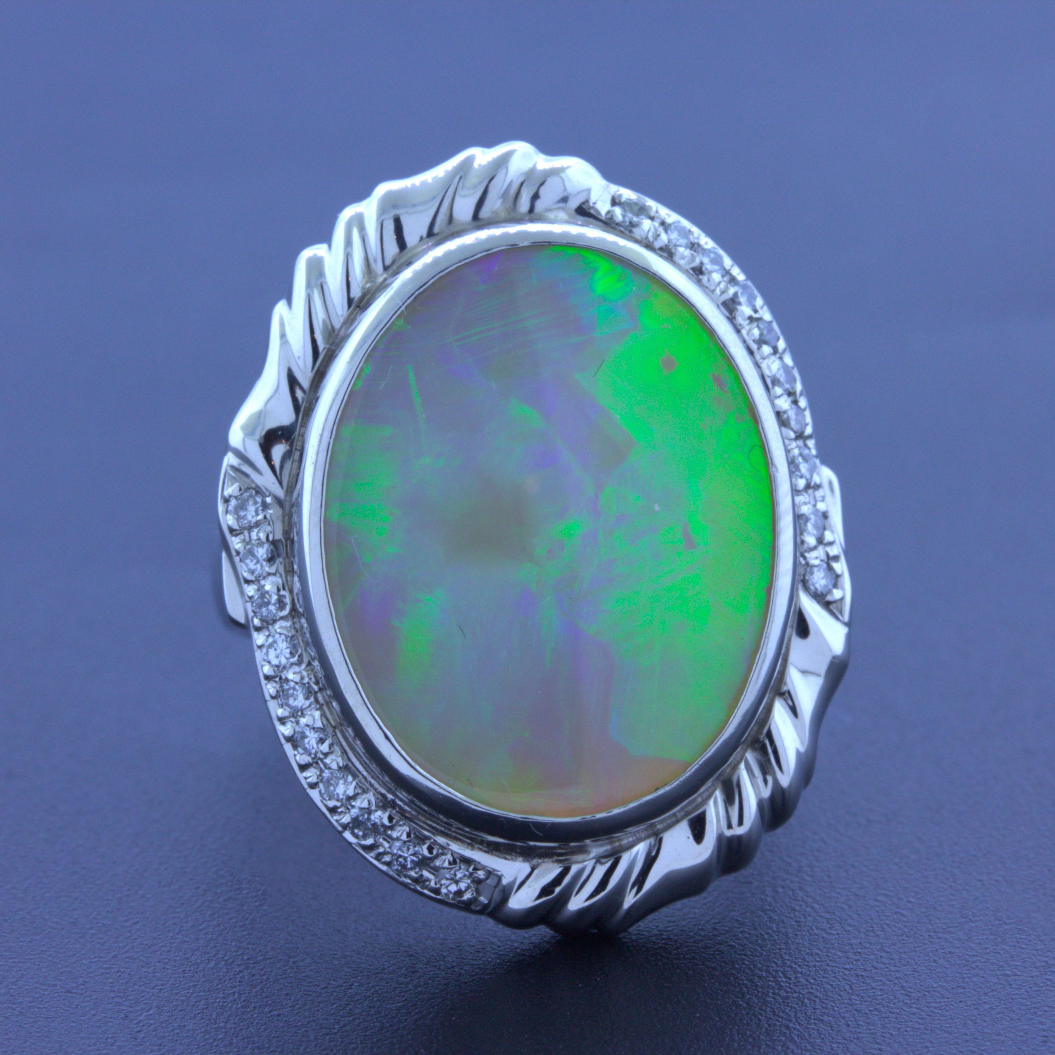 A lovely Australian opal weighing 12.56 carats is the center of this platinum ring. It has fantastic play-of-color with a rare feather pattern that runs east to west showcasing flashes of green and blue with hints of yellow. It is complemented by