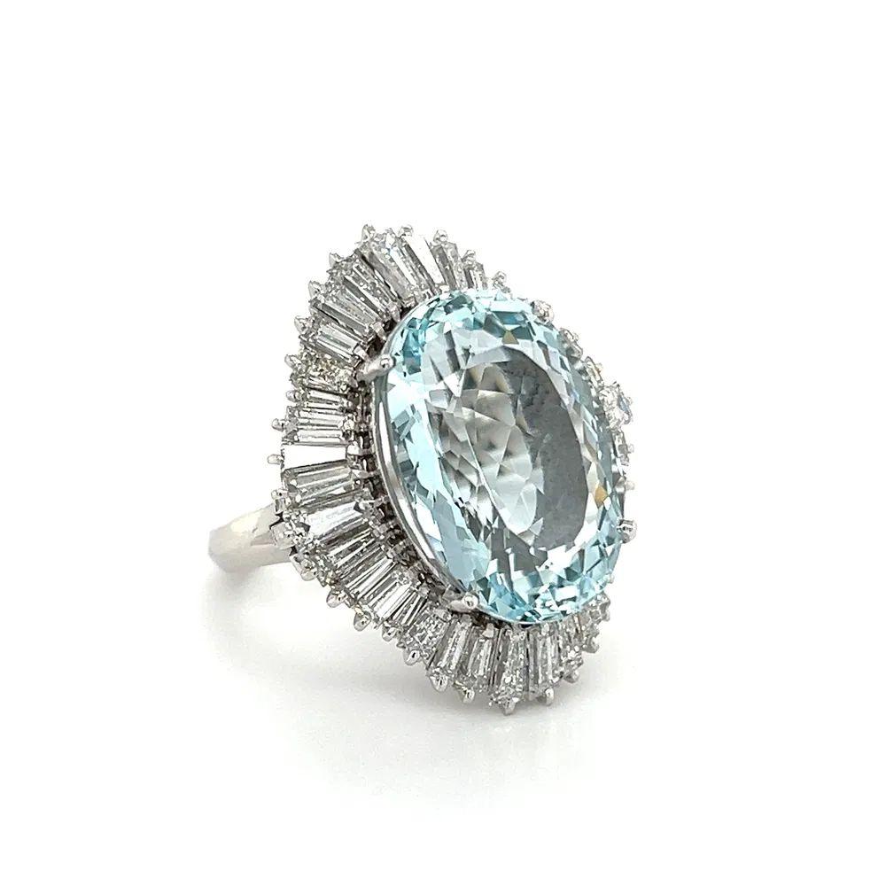 Simply Beautiful! Finely detailed Aquamarine and Baguette Diamond Platinum Ballerina Ring. Centering a securely nestled Hand set Oval Aquamarine Gemstone, weighing approx. 12. 57 Carats. Surrounded by dazzling Baguette Diamonds, approx. total weight