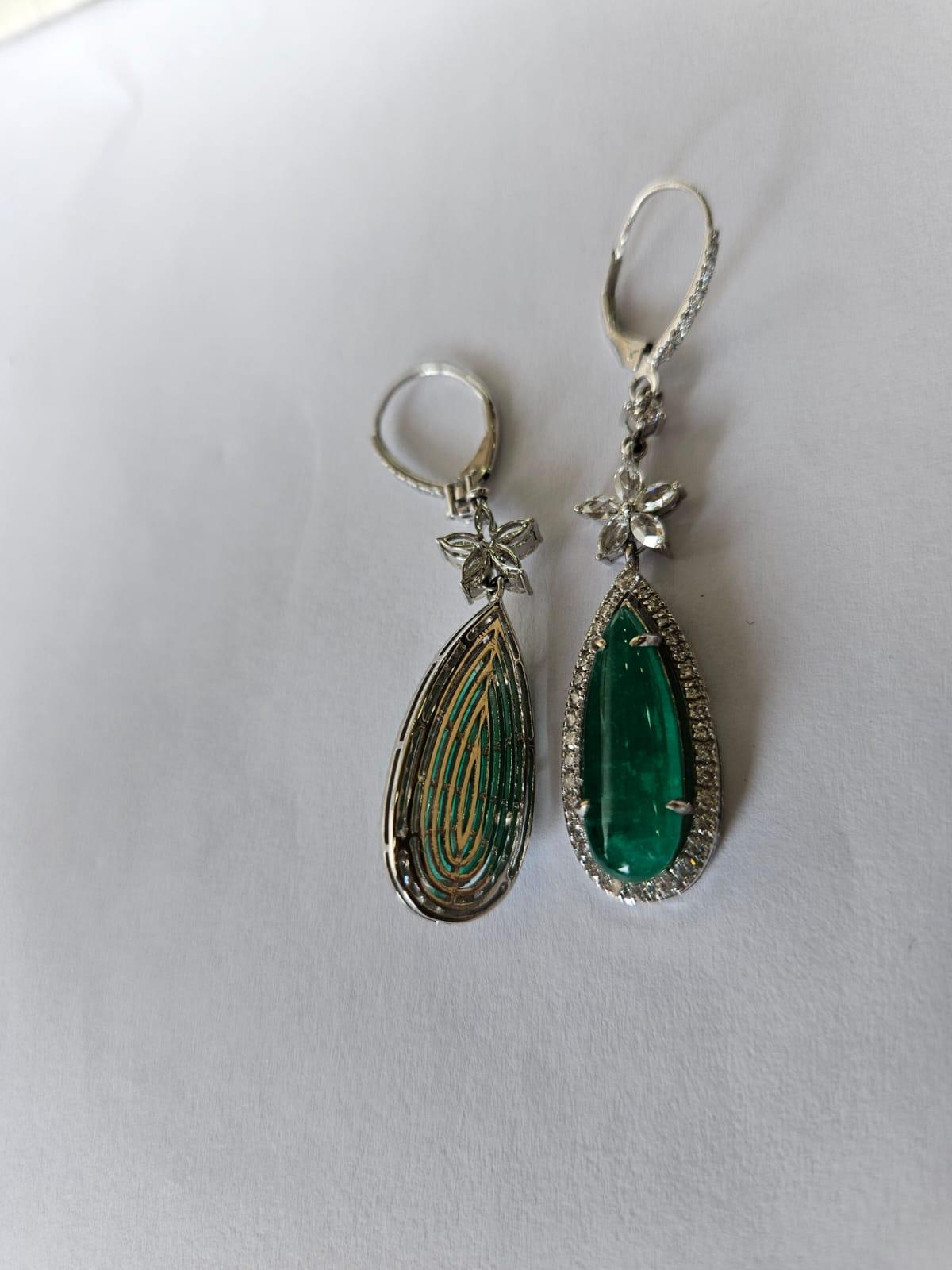 Magnifiques boucles d'oreilles pendantes de style moderne en or blanc 18 carats et diamants naturels, avec un chandelier d'émeraudes. Le poids des cabochons d'émeraude est de 12.57 carats. Les émeraudes sont entièrement naturelles, sans aucun