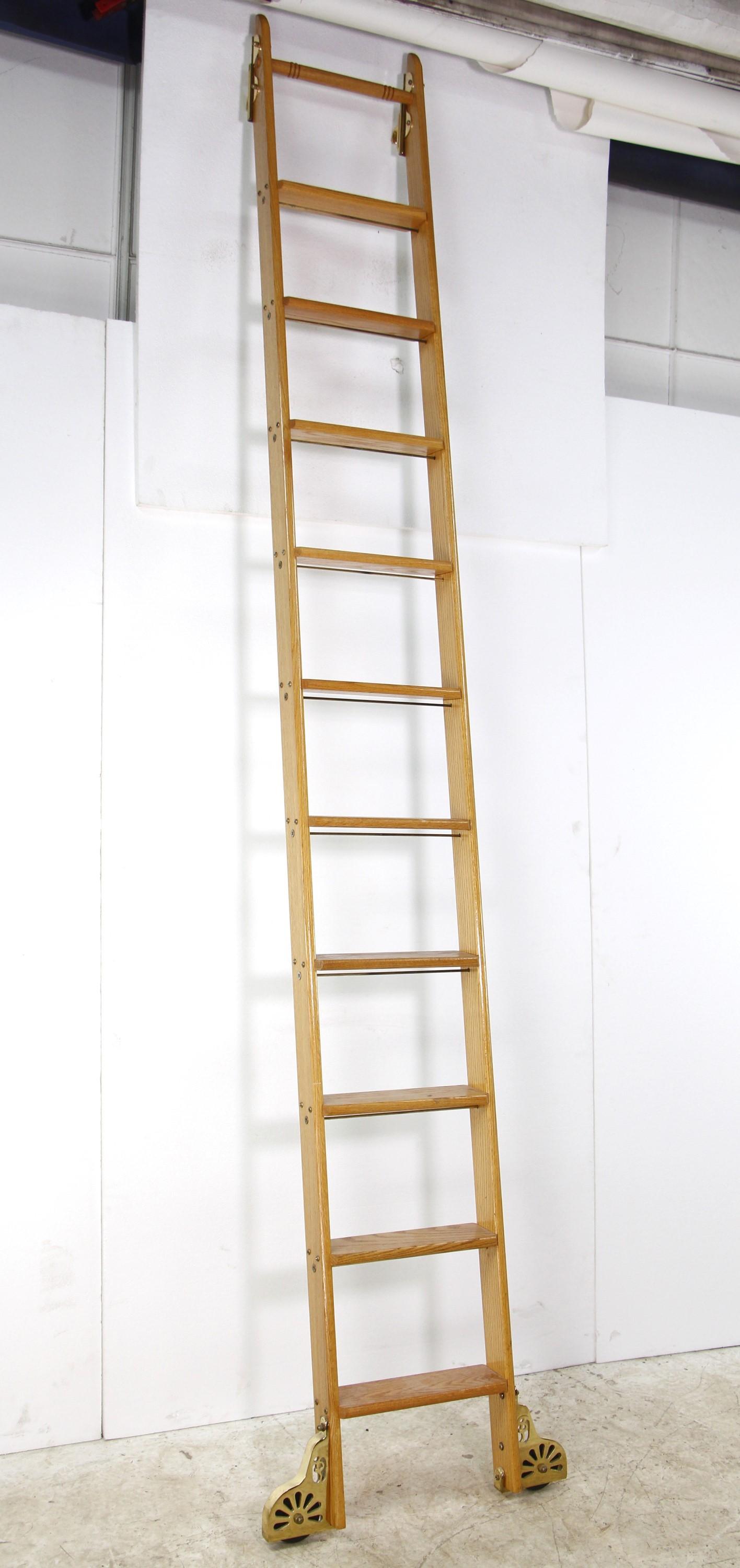 Mid-20th century oak library ladder in a light stain. Original Putnam Rolling Ladder Co, Inc. sticker, Features brass plated steel hardware and side rolling bottom wheels. No top wheels. Made by Putnam Rolling Ladder Co., Inc. Please note, this item