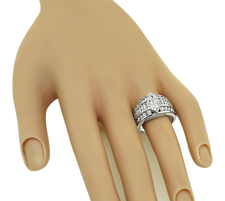 Questo è un fantastico anello in oro bianco 14 carati. L'anello è centrato da uno scintillante diamante taglio marquise del peso di circa 1,25 ct. Il colore del diamante è F con purezza SI3. Il diamante centrale è accentuato da splendidi diamanti a