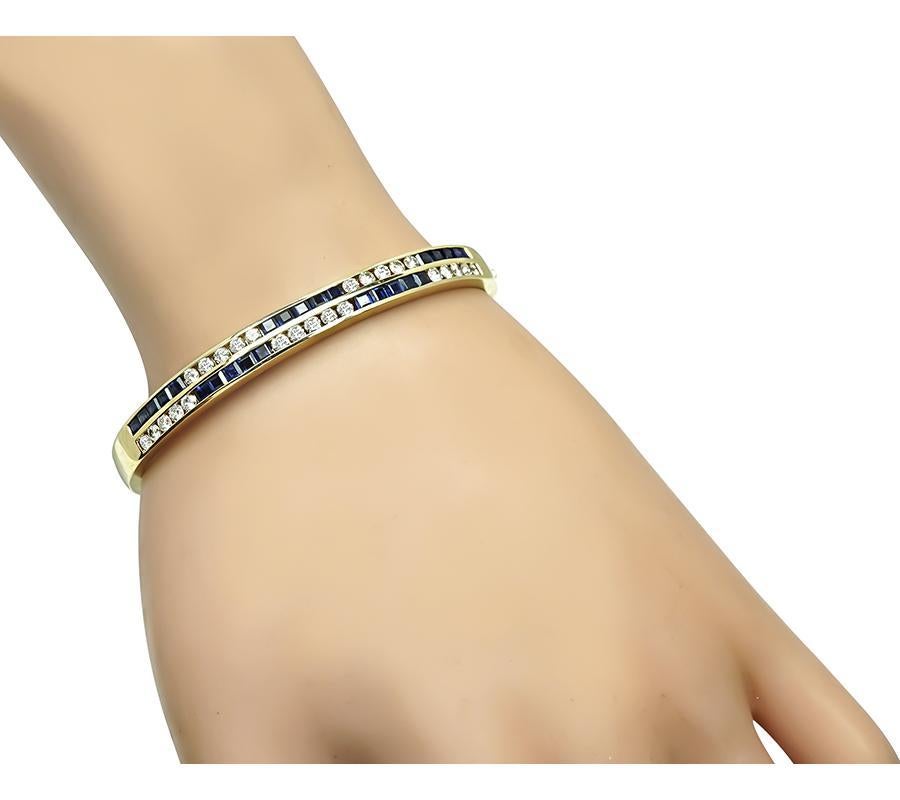 This is a beautiful 14k yellow gold bangle. The bangle is set with sparkling round cut diamonds and square cut sapphires that weigh approximately 1.25ct and 1.50ct respectively. The color of these diamonds is I with VS clarity. The bangle measures