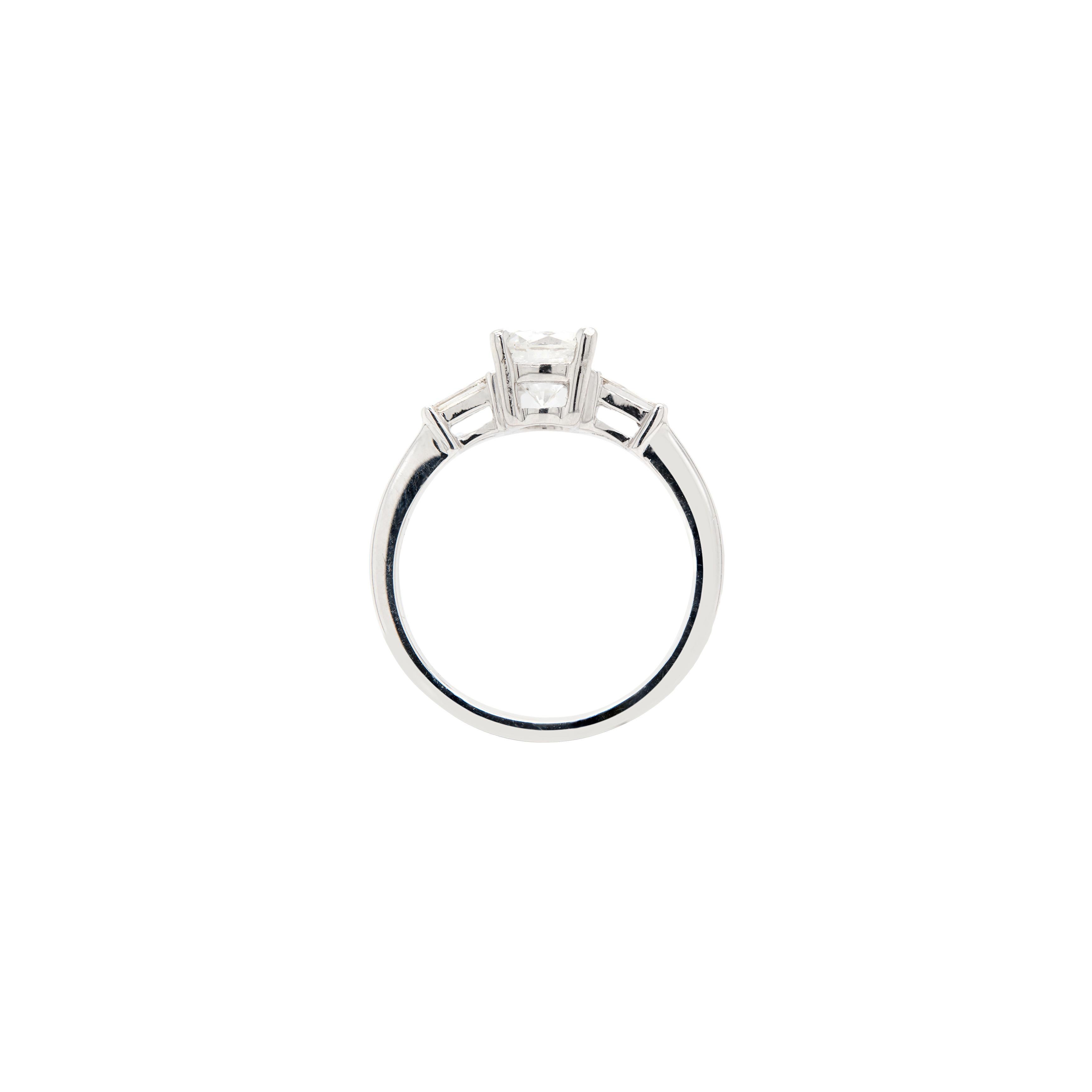 An epitome of enduring elegance, this 18 carat white gold engagement ring boasts a fantastic trio of stunning diamonds.

At its centre sits proudly an impressive 1.25ct round brilliant cut diamond, held in place by an exquisite four claw, open back