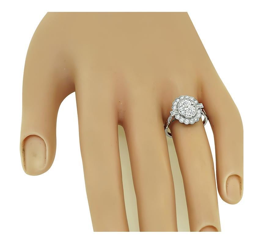 This is a stunning platinum engagement ring. The ring is centered with sparkling oval cut diamond that weighs approximately 1.25ct. The color of the diamond is H with SI1 clarity. The center diamond is accentuated by dazzling round and baguette cut