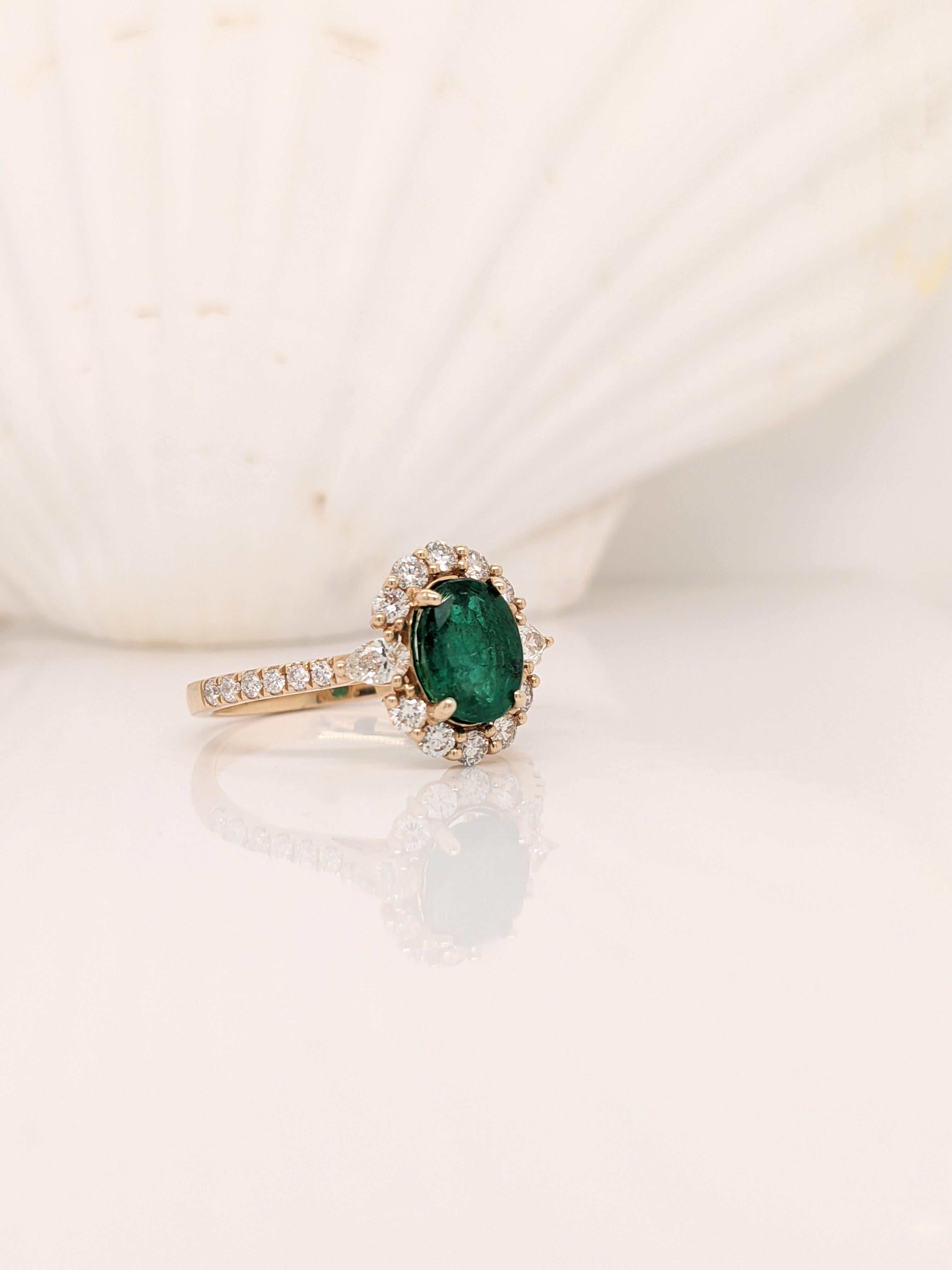 Green emerald in 14k Yellow Gold with natural earth-mined round and pear Diamond accents. This ring has a pronged basket and a diamond studded shank. A beautiful ring design perfect for an eye catching engagement or anniversary. This ring also makes