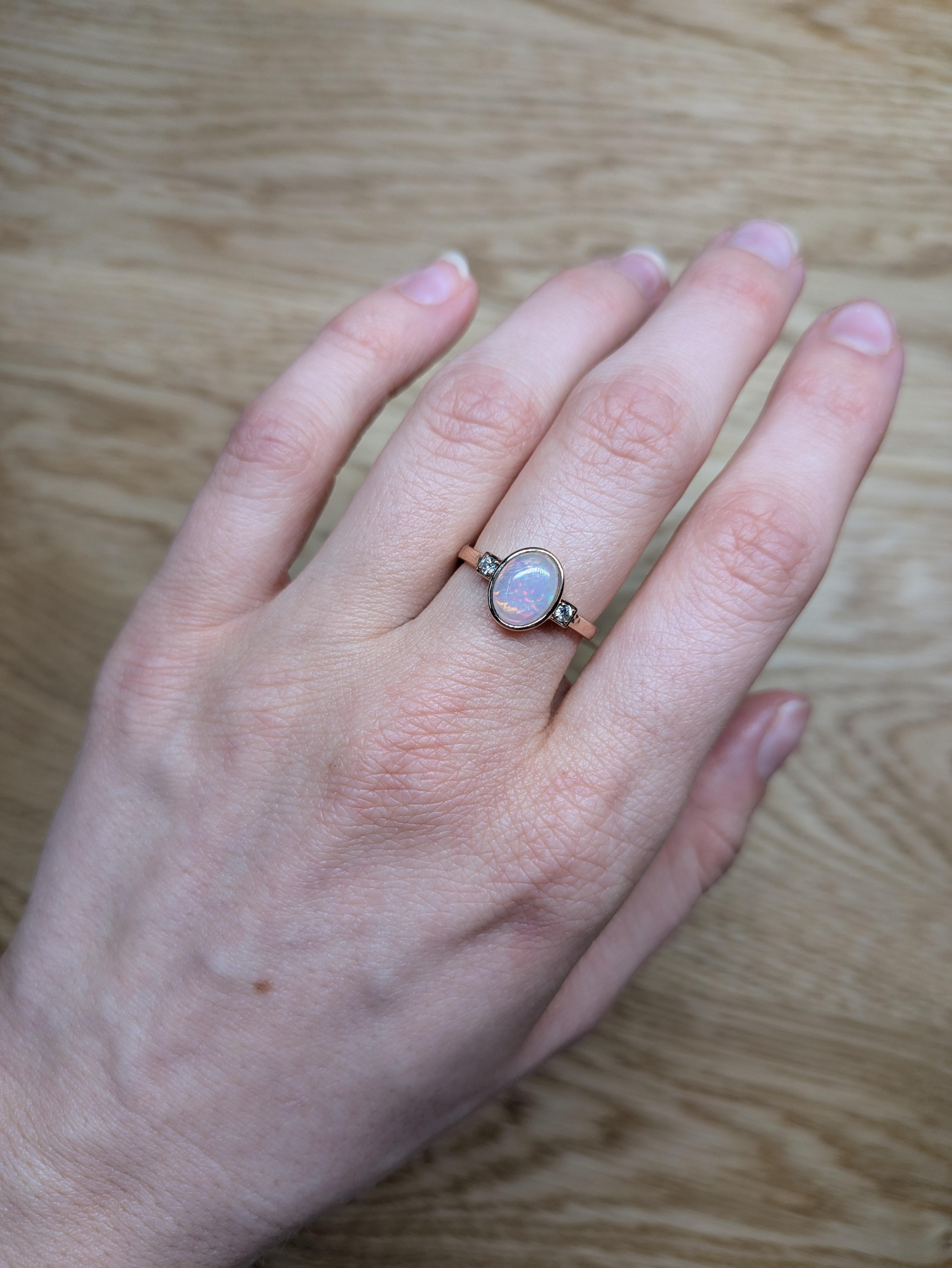 This lovely 1.25 carat opal has all the colors of the rainbow, accented with natural earth mined diamonds set in 14k yellow gold. An elegant bezel set ring design makes this glowing ring perfect for the modern bride or that special someone in your