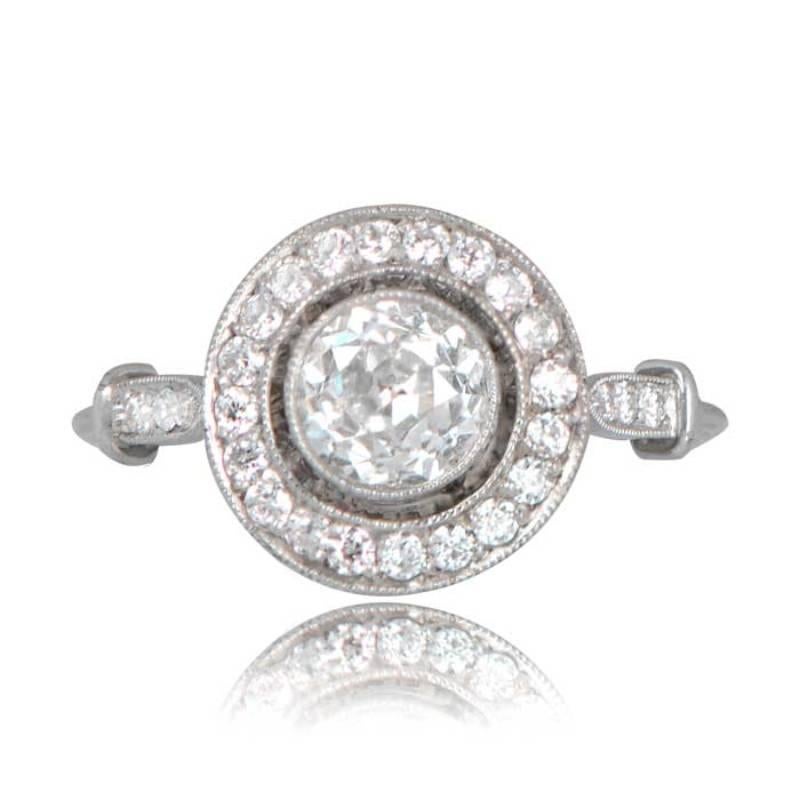 The Brighton Ring is a stunning halo engagement ring, featuring an exquisite old mine-cut diamond set within a handcrafted platinum bezel. The delicate design is enhanced by a triple wire shank and diamond accents along the shoulders. The center