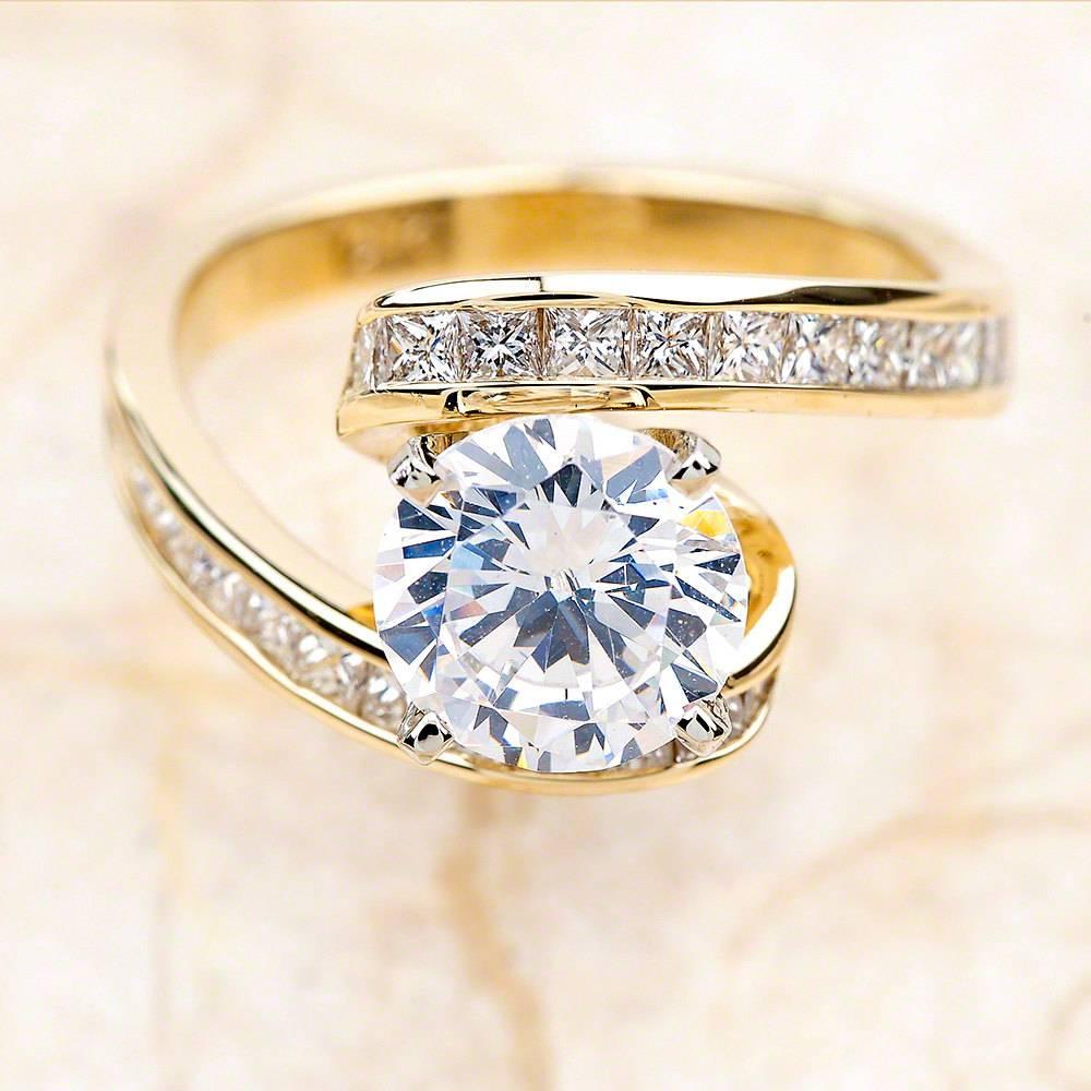 - Center Stone: Round Cut Moissanite 7mm (1.25ct)
- Side Stones: Princess Cut Diamonds 2.00ctw / Graded G SI1
- Metal: 14K Yellow Gold

This piece is made-to-order. Please allow up to 7 Business Days to accomplish.