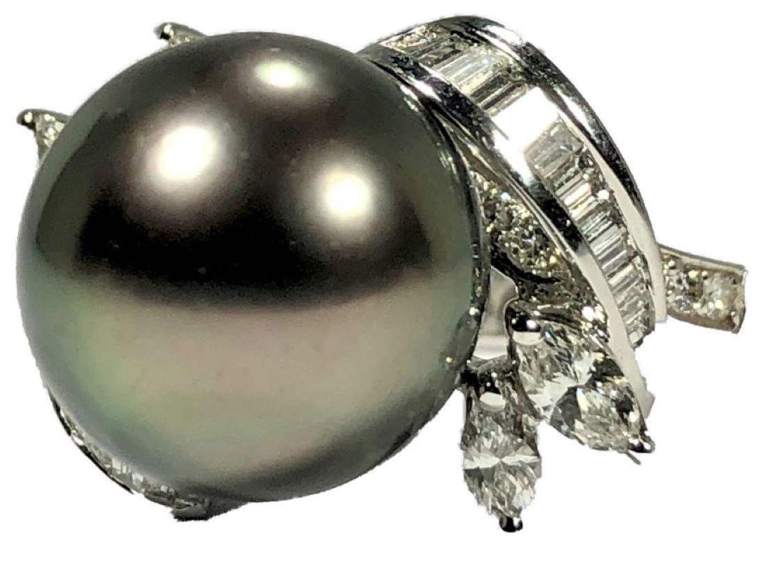 This lovely 18k white gold ring features, at it's center, one 12.5mm Tahitian grey pearl which is framed by marquise, baguette and round diamonds having a total approximate weight of 1.10ct of overall G Color and VS1 Clarity. The center pearl is of