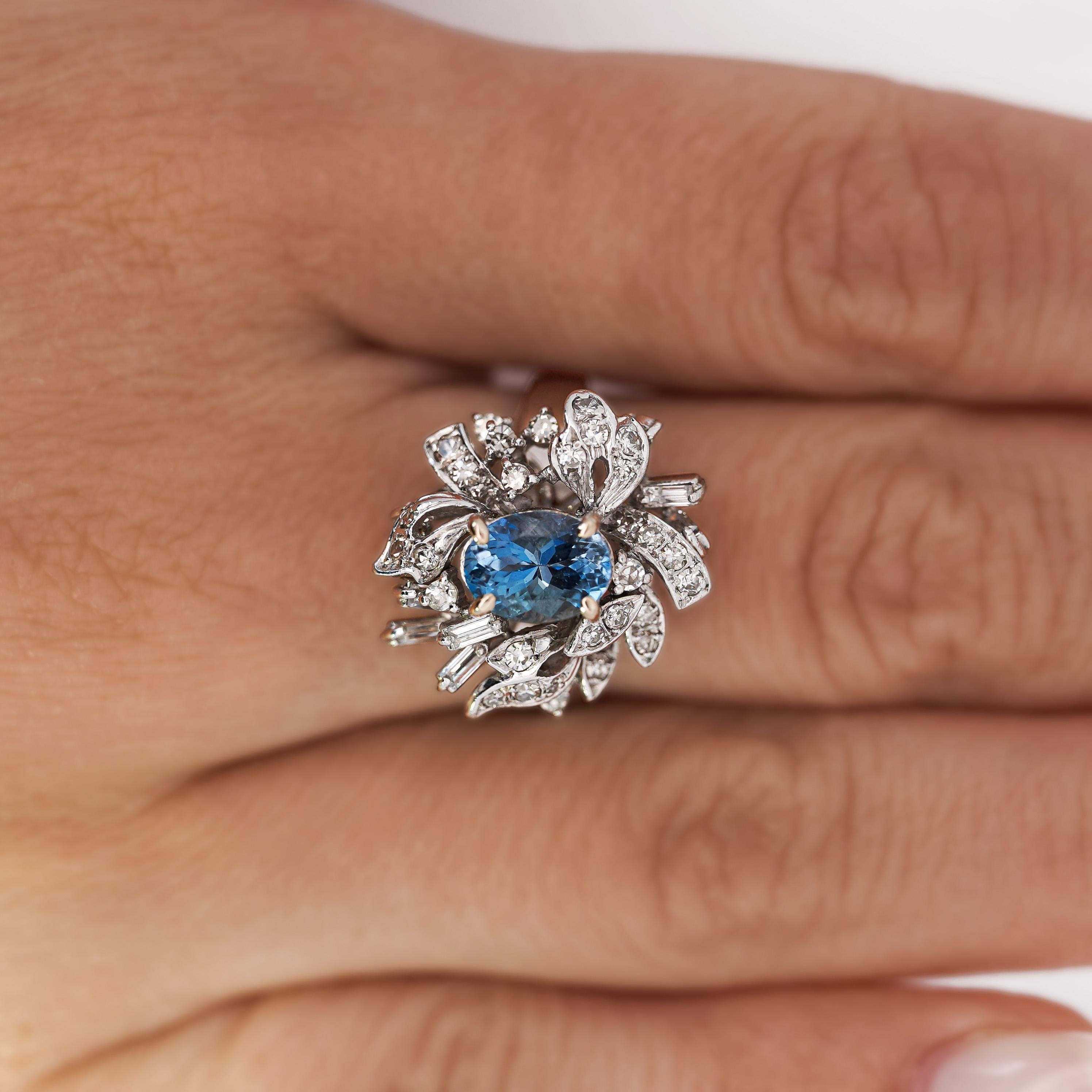 Cette bague exquise en or 18 carats est ornée d'une superbe aigue-marine de 1,26 carats entourée de 32 diamants d'un poids total de 0,75 carats. Son design élégant, caractérisé par un équilibre entre l'or classique et les diamants étincelants, est