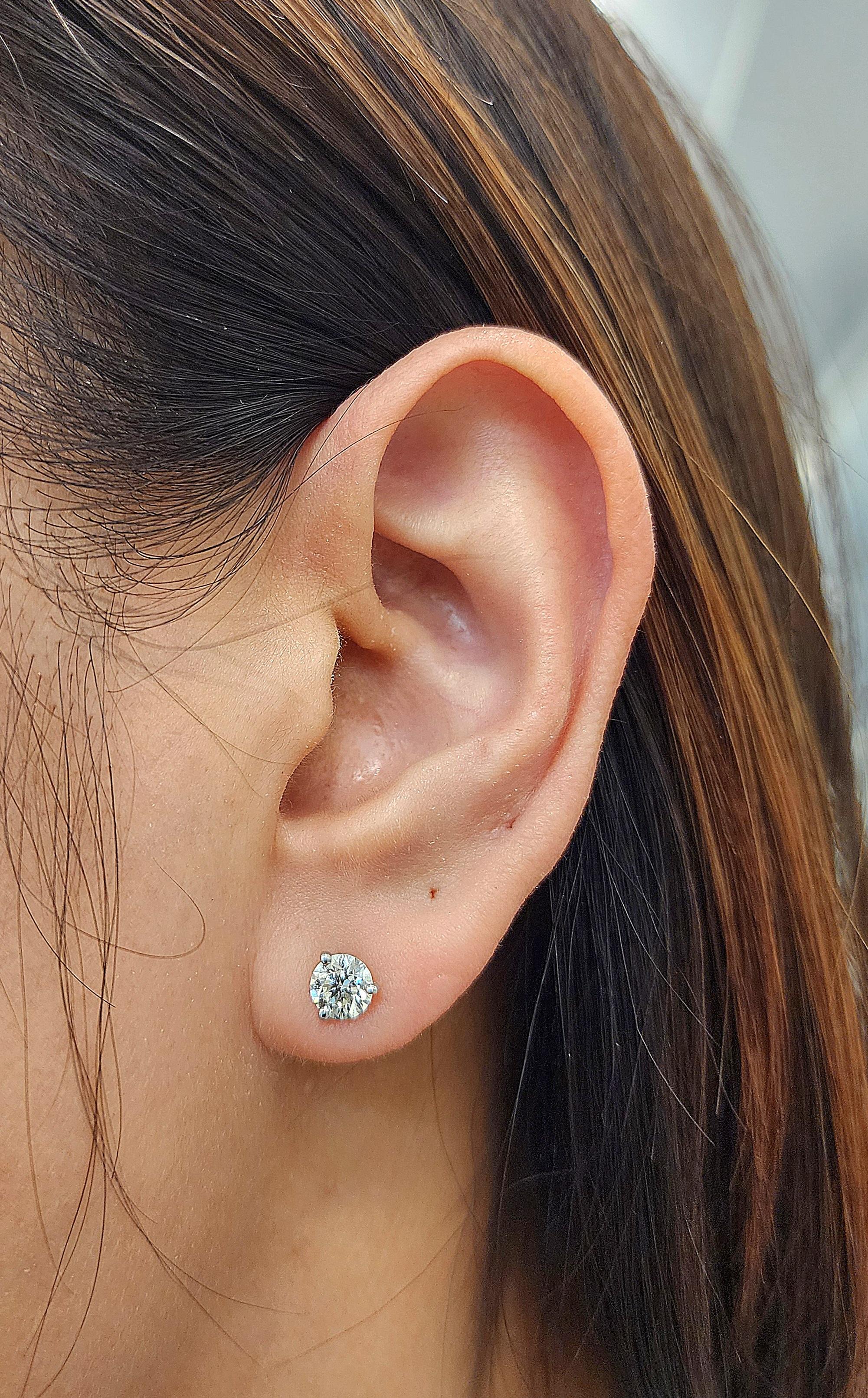 These elegant stud earrings feature 1.26 carats of round-cut diamonds set in 14 karat white gold. The diamonds are F/G in color and VS2/SI1 in clarity, which makes them a refined choice for any occasion. Their classic design ensures that they will