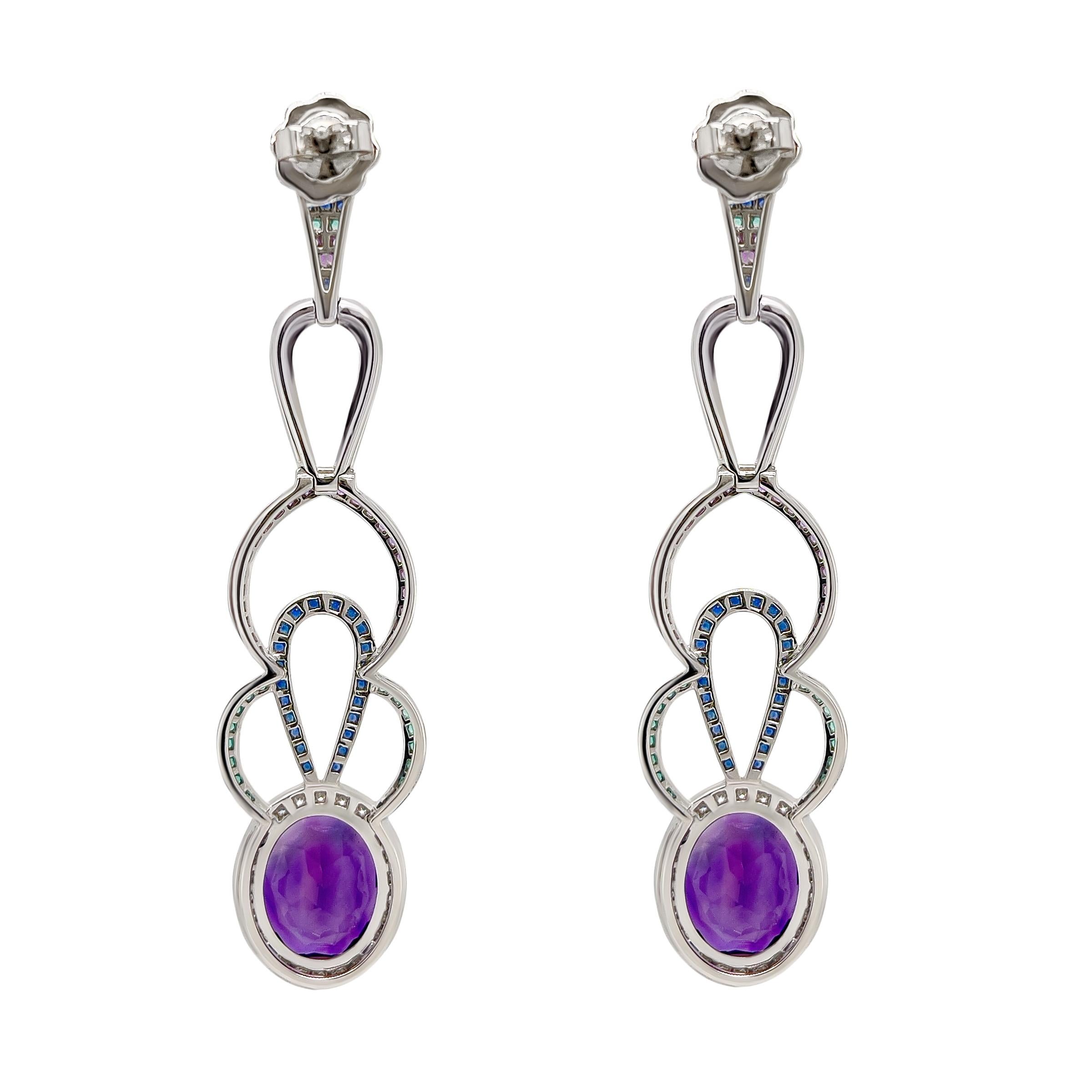 Perfectly coloured amethyst are the highlight of these 18k white gold pair of earrings. The 12.62 carat centre stones are surrounded by pave diamonds in vvs quality to help enhance their colour. The natural blue and green sapphires add a pop of