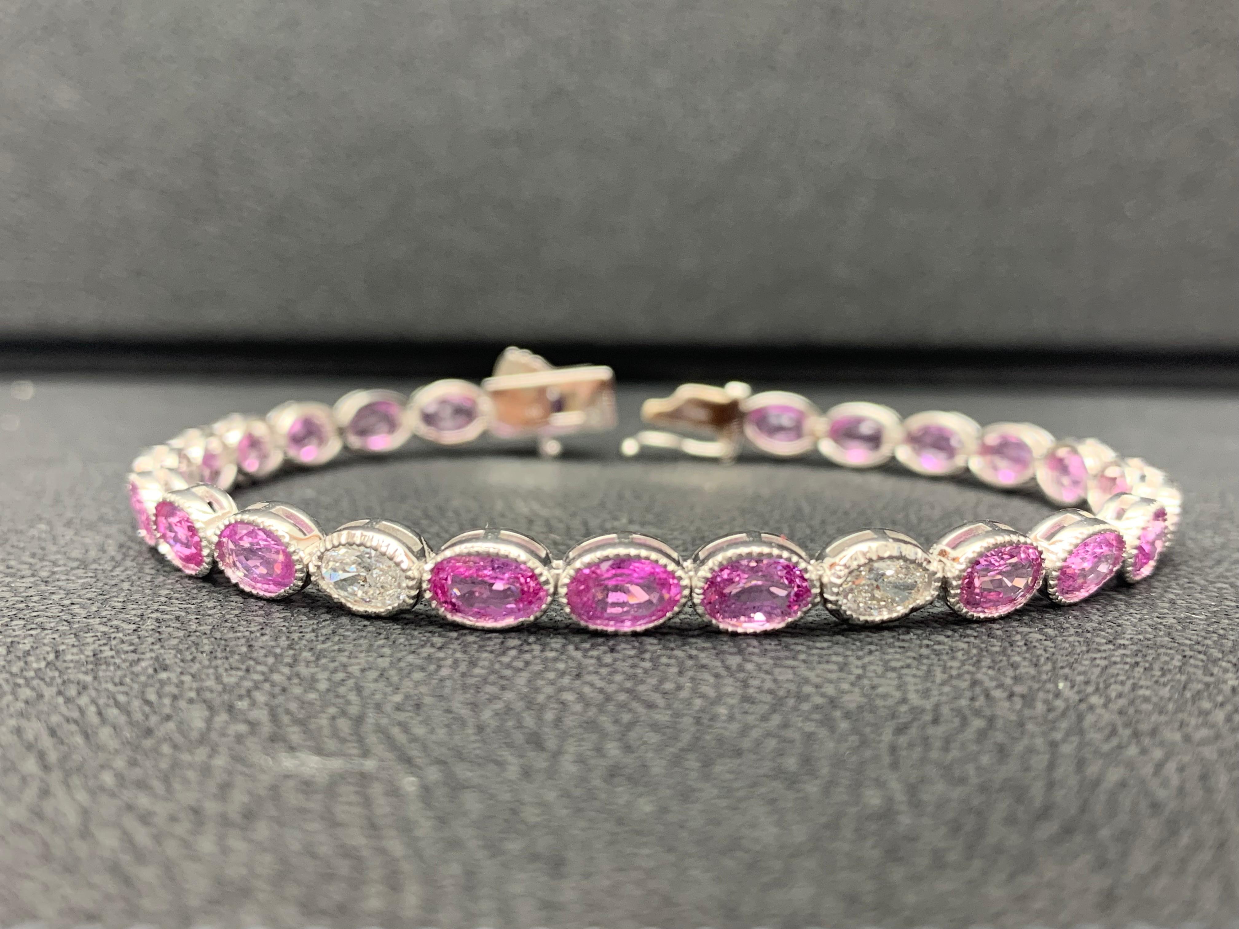 A classic and simple tennis bracelet style featuring 23 Oval cut brilliant pink sapphire weighing 12.62 carats and 2 oval cut brilliant diamonds weighing 0.65 carats total. Set in a polished 14k White gold mounting. 

All diamonds are GH color SI1