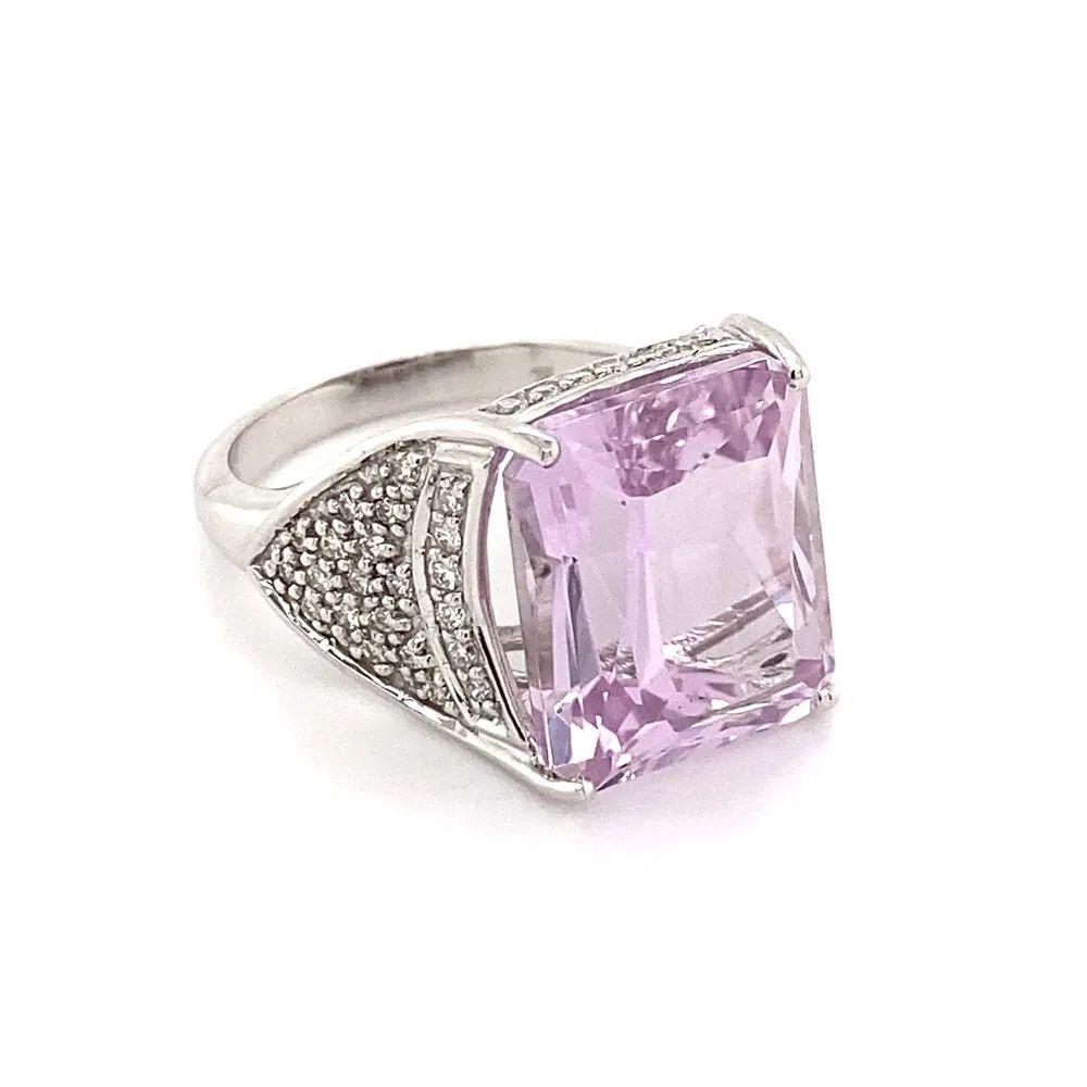 Simply Beautiful! Solitaire Kunzite and Diamond Gold Cocktail Ring. Centering a Hand set securely nestled 12.64 Carat Kunzite. Enhanced either side of shank with Diamonds, weighing approx. 0.43tcw. Hand crafted 18K White Gold mounting. Ring size 7,