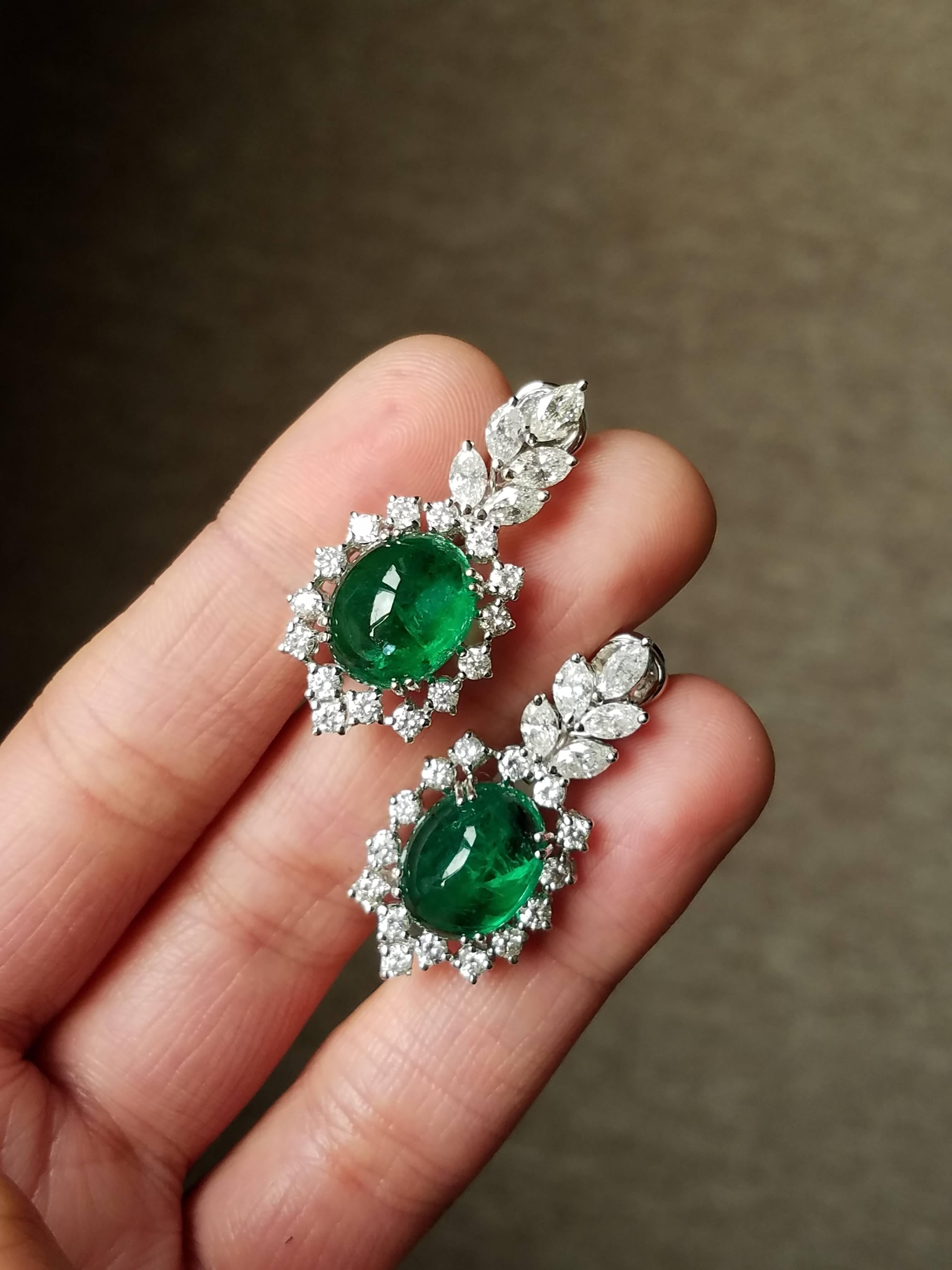 A beautiful pair of Zambian Emerald Cabochon earrings, of great quality and colour set in 18K White Gold and round/marquise shaped White Diamonds. 

Stone Detail:
Stone: Zambian Emerald 
Total Weight: 12.66 carat

Diamond Detail:
Total Weight: 3.31