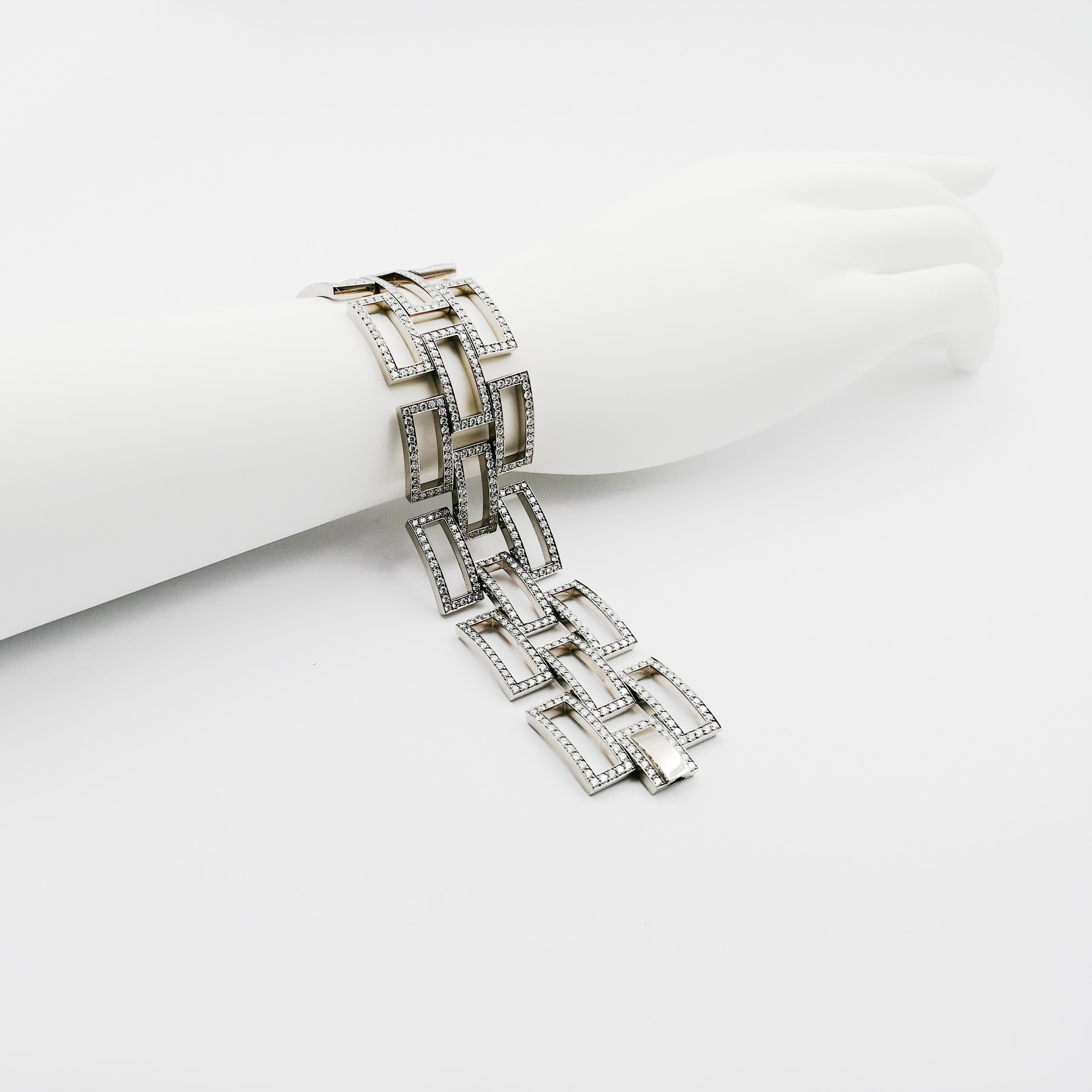 This extraordinary piece attempts to unite geometrical, straight-lined shapes with soft and elegant moveability. The bracelet is composed of rectangularly arranged rows of brilliant-cut diamonds (F / VVS), handmade in 18 karat white gold. Invisible