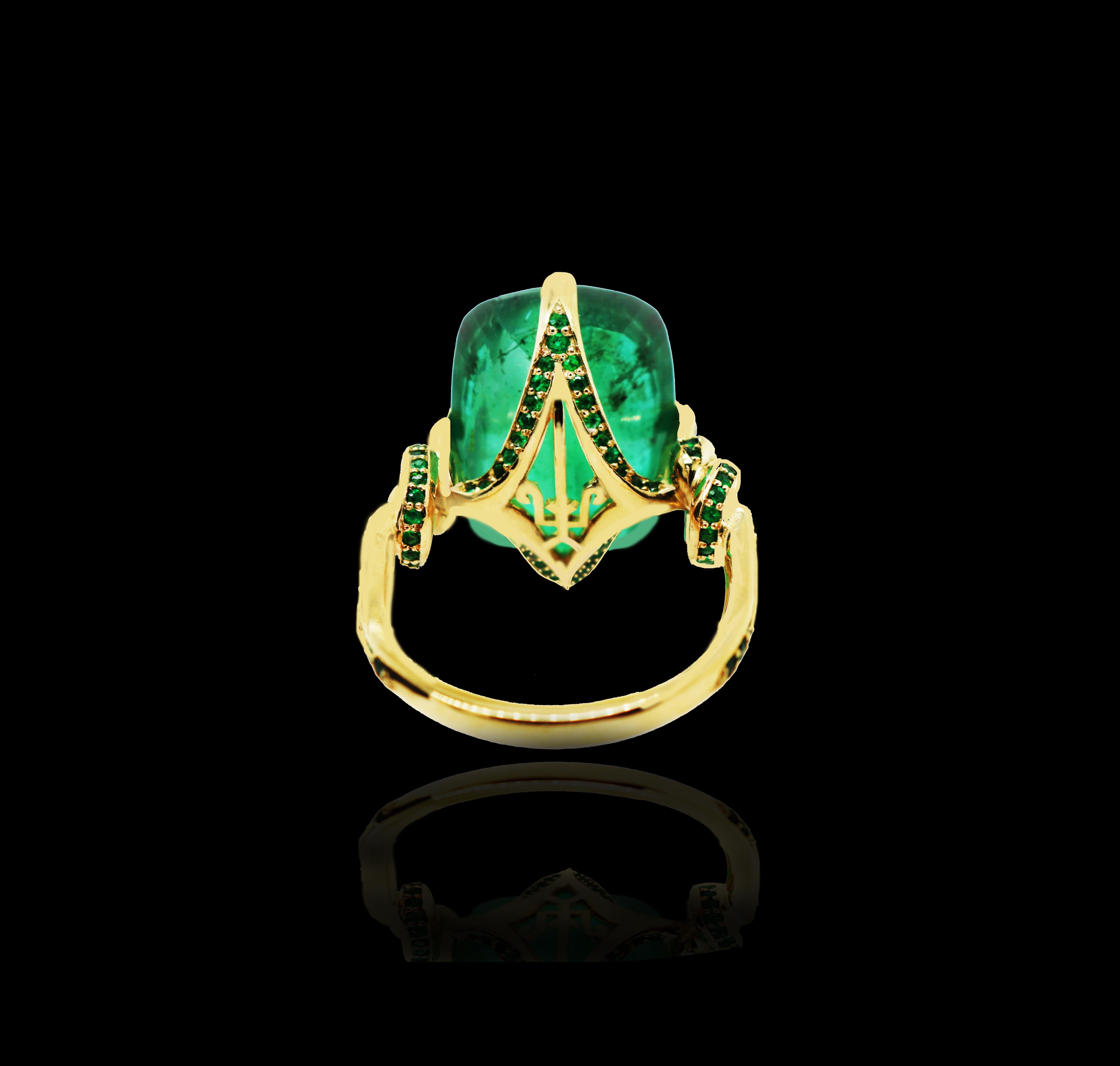 Glamorously bold and unabashedly seductive. This showstopper ring features an intense natural Emerald poised between sharp eagle style talons and embraced by powerful golden, emerald encrusted ropes, converging to two knots on either side of the