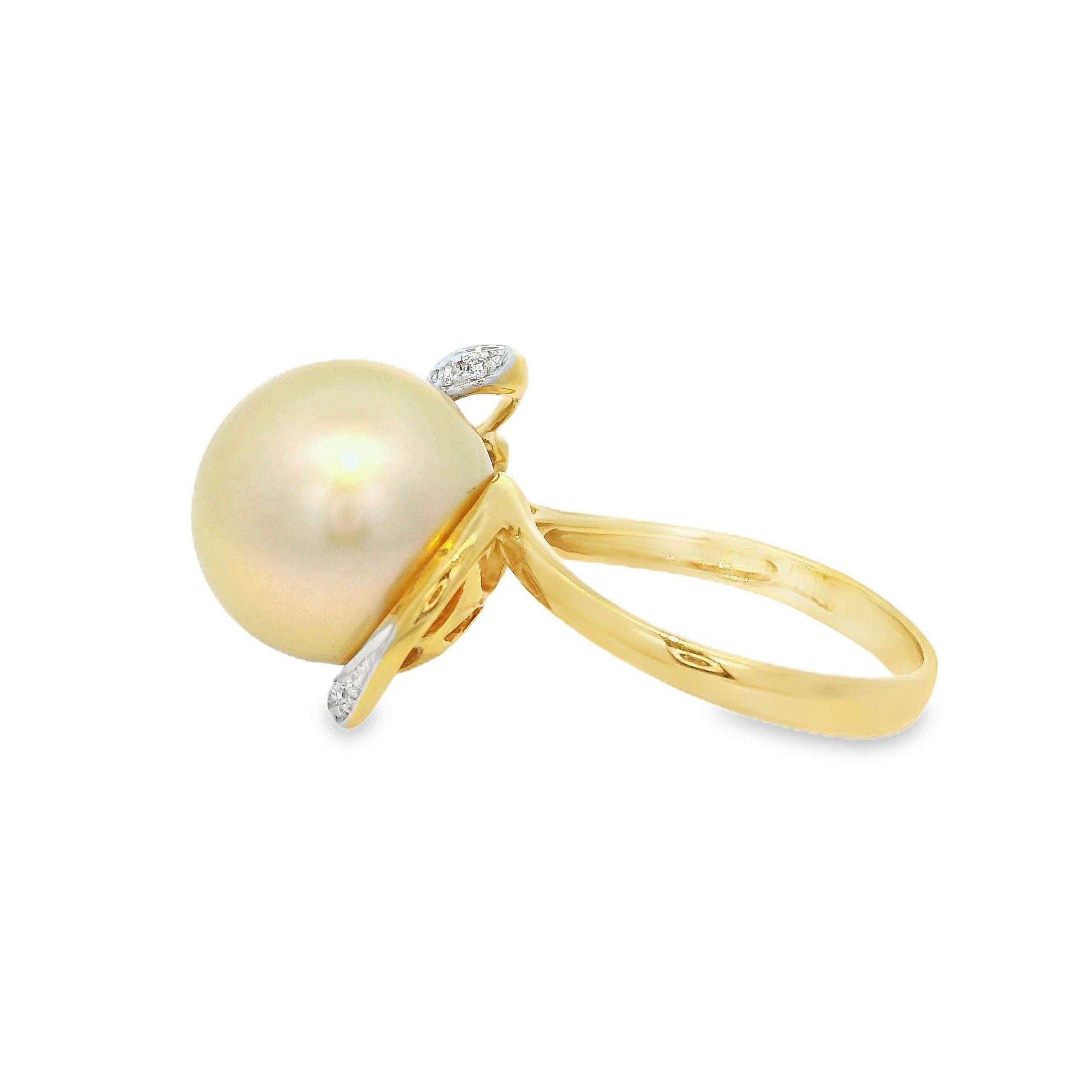 This elegant ring showcases a lustrous 12.6 mm golden South Sea pearl, known for its exceptional size and radiant glow. The pearl is beautifully complemented by a delicate arrangement of diamonds, totaling 0.14 carats, which add a touch of