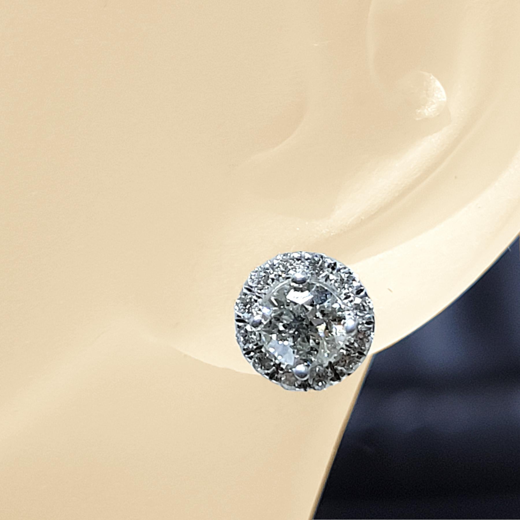 This beautiful pair of earrings is made in 14K Gold with a pair of Round Brilliant Diamonds with total weight of 1.00 Ct in the center of a Pave Set Halo with 30 pieces of 1.1 mm Round Brilliant diamonds. Diameter: 8 mm
Total Diamond weight is 1.27