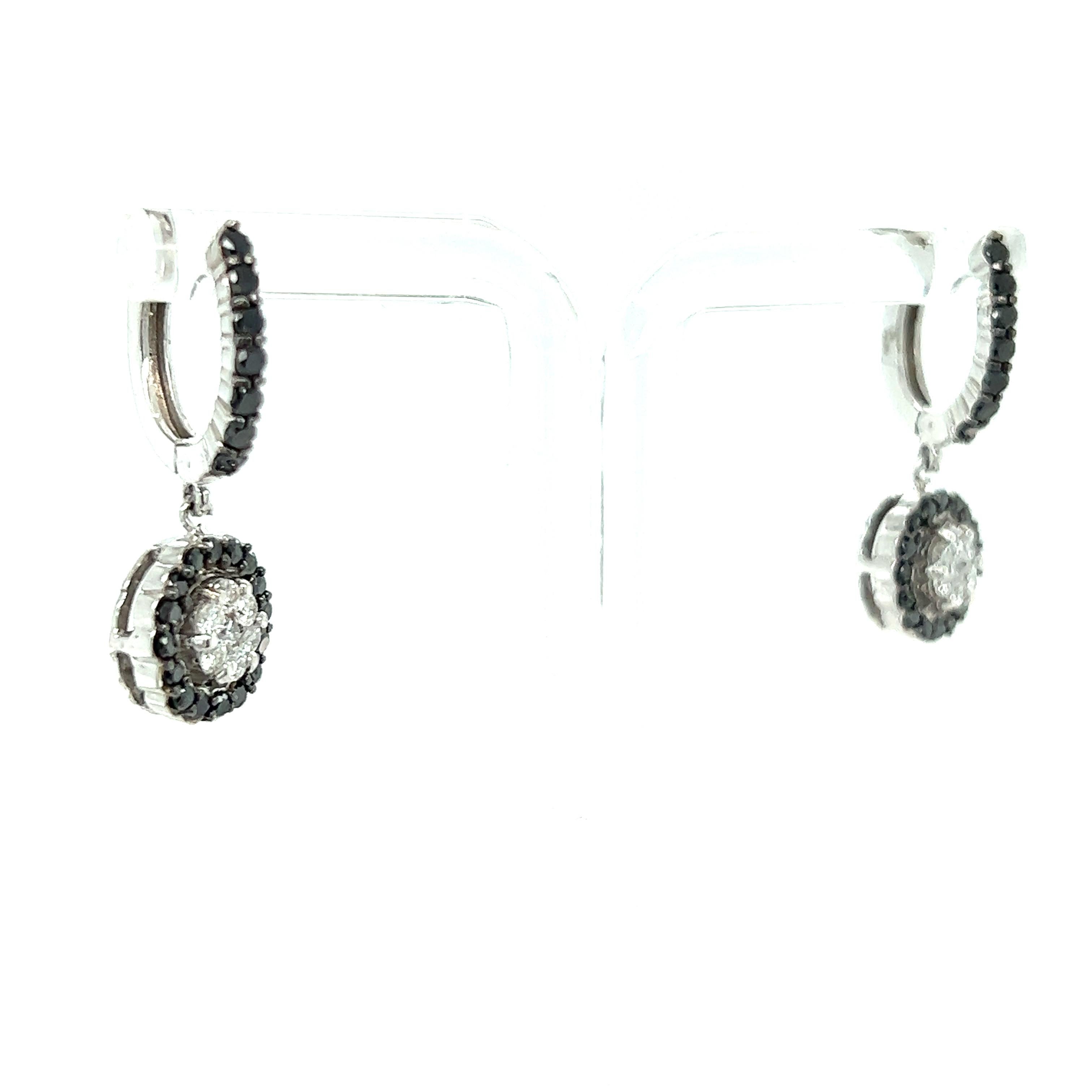 These earrings have Natural Black Round Cut Diamonds that weigh 0.85 Carats and Natural Round Cut White Diamonds that weigh 0.42 Carats. The total carat weight of the earrings are 1.27 Carats. The clarity and color of the white diamonds are