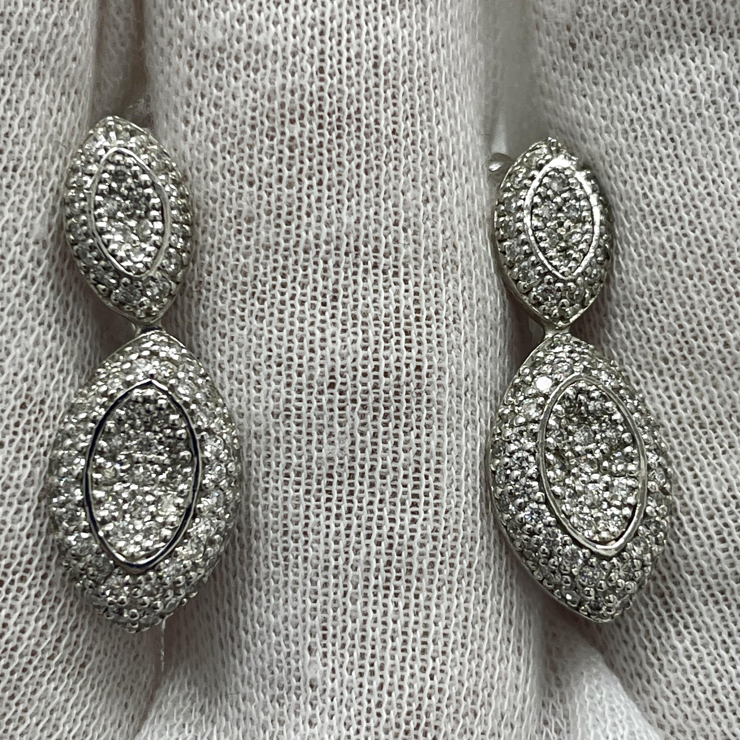 These elegant 14K white gold dangling earrings carry 1.27Ct of brilliant white diamonds